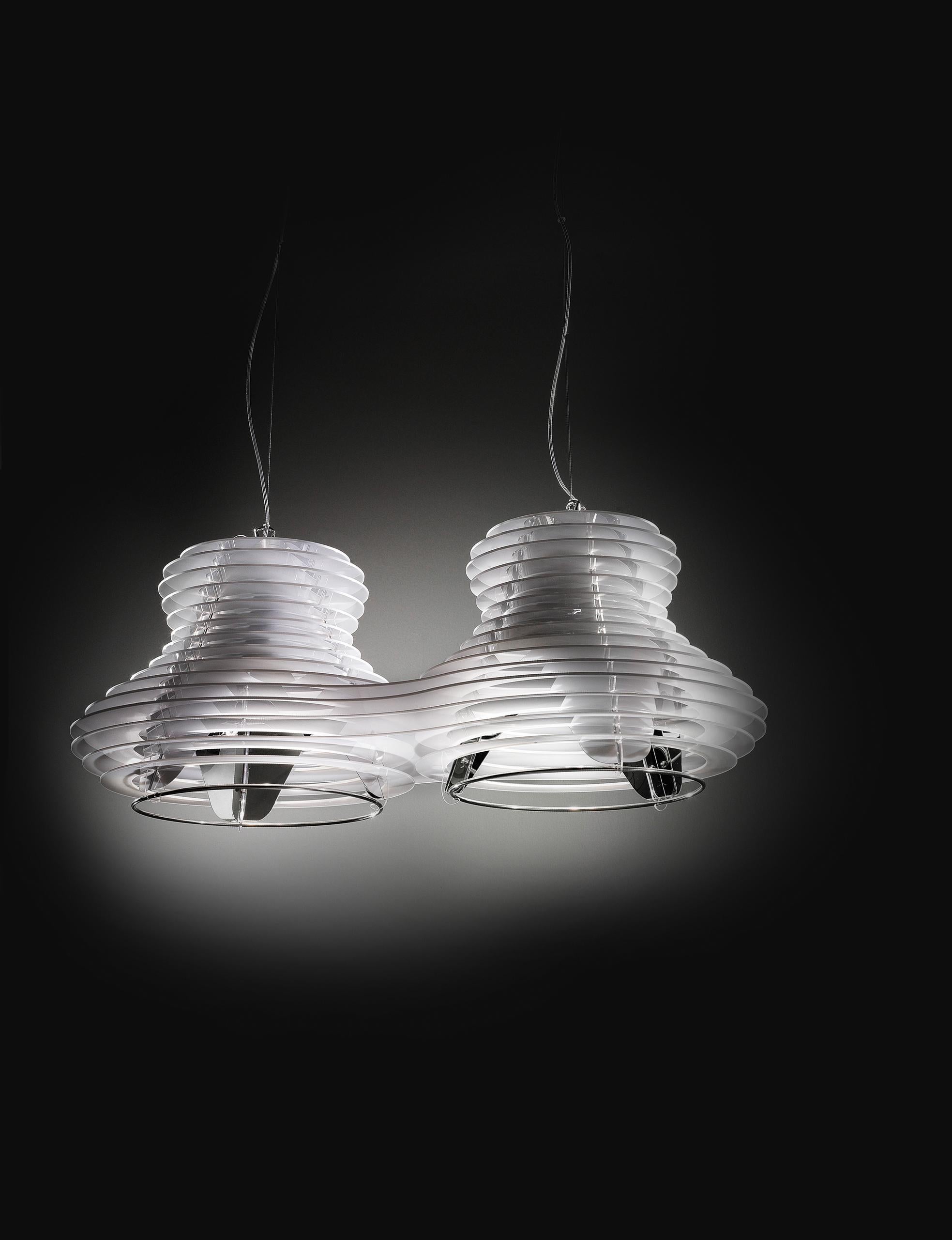 A modern shape, rigorous geometry, rigid and penetrating lines that soften around a central cone surrounded by layered rings that play with the light without losing form. The lamp’s curves were inspired by the evocative rolling hills of the Tuscan