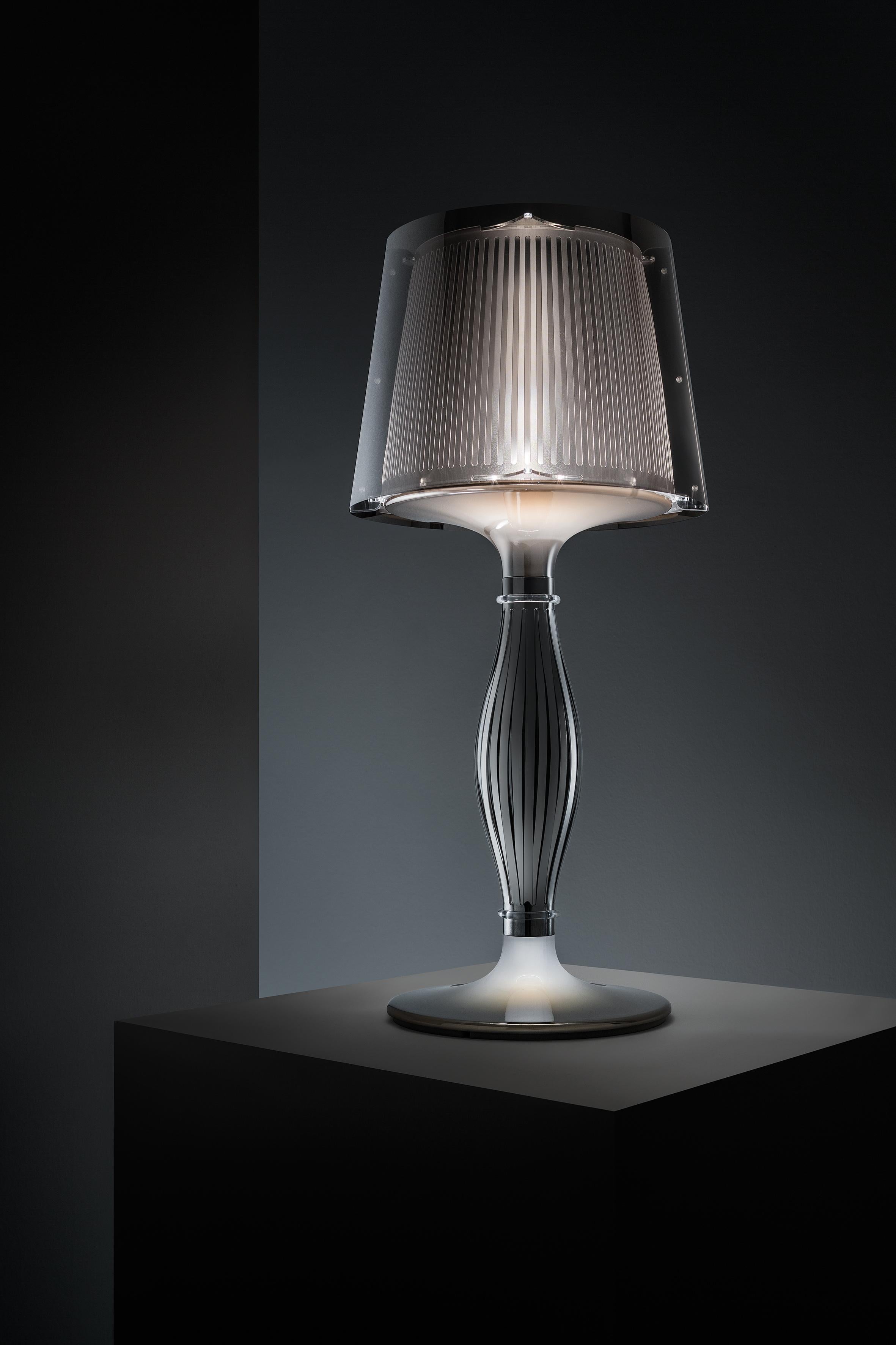 The masterpiece of the Liza collection is the iconic, baroque-inspired table lamp, available in the classic Prisma version, as well as a new Pewter version, both using SLAMP’s patented techno-polymer materials. Liza has a double illumination system,