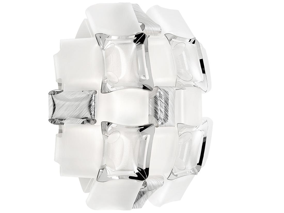 Mida s'inspire de l'univers des bijoux de haute couture. Un pavé de pierres précieuses incruste une monture presque invisible, et des cabochons polis sont dispersés géométriquement sur une corolle florale aux tons soyeux et irisés. Le designer a