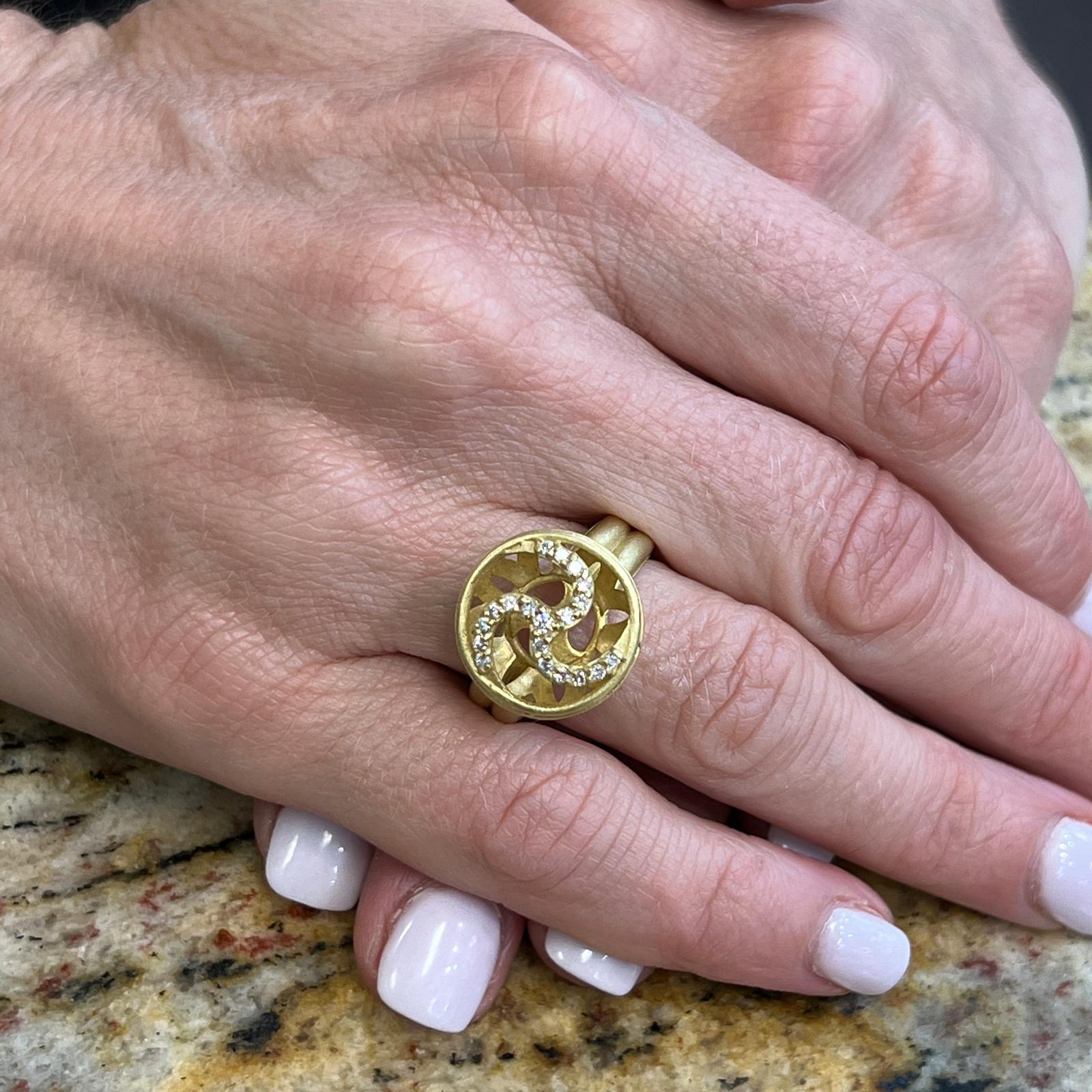 Diamond ring by designer Slane & Slane fashioned in brushed finish 18 karat yellow gold. The ring features 19 round brilliant cut diamonds weighing approximately .40 CTW and graded G-H color and VS clarity. The top measures 16mm in diameter, and the