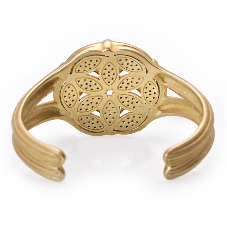 This fabulous Fenestra Cuff from Slane & Slane in 18K yellow gold is absolutely outstanding.The cuff slides onto the average wrist easily. The cuff widens to a stunning Fenestra design that offers the wearer a look into the window and the ~2ct of