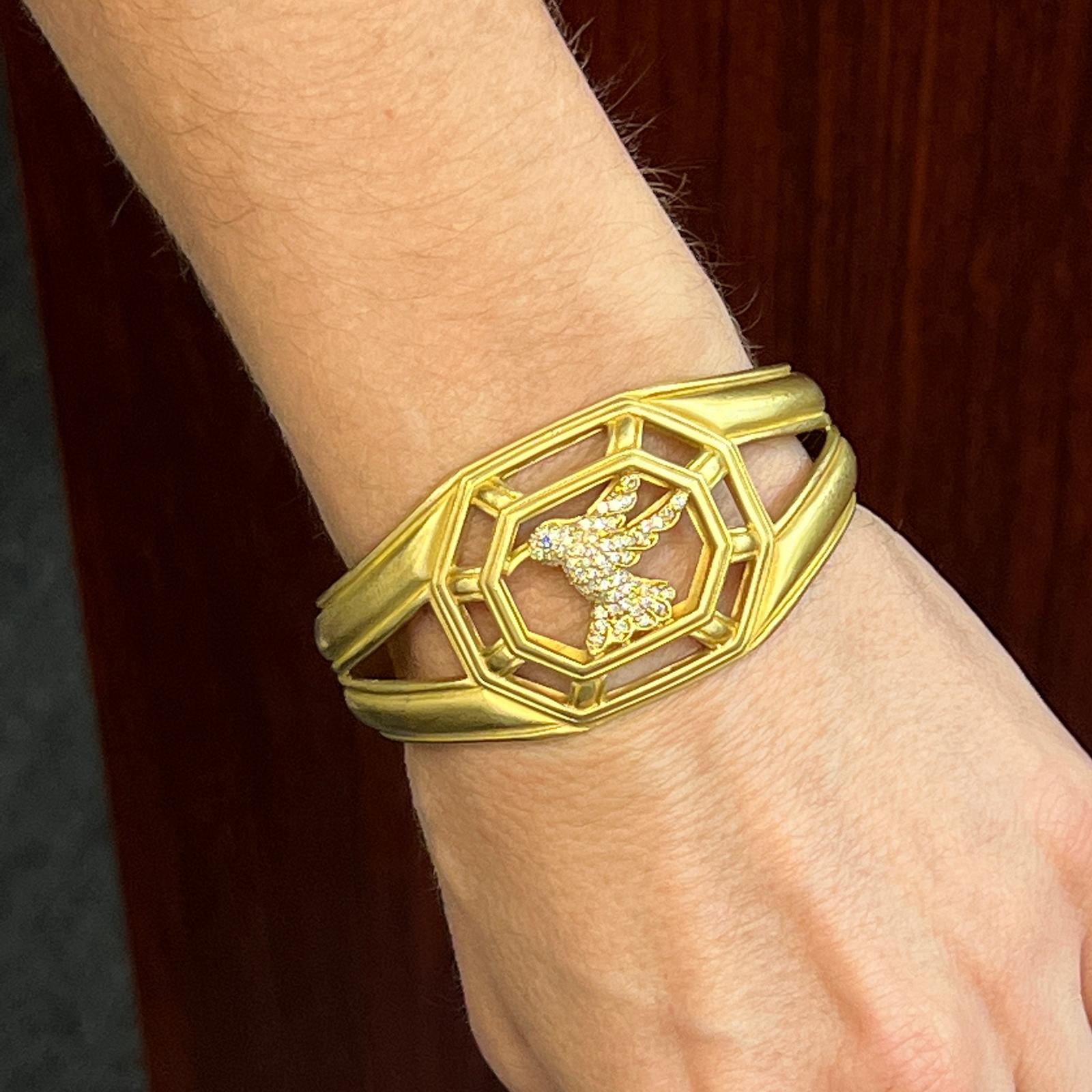 Beautiful Slane & Slane Diamond Hummingbird cuff bracelet fashioned in 18 karat yellow gold. The hummingbird is crafted in round brilliant cut diamonds weighing approximately .75 CTW and graded G/VS1. The cuff measures 1.25 inches in width, and