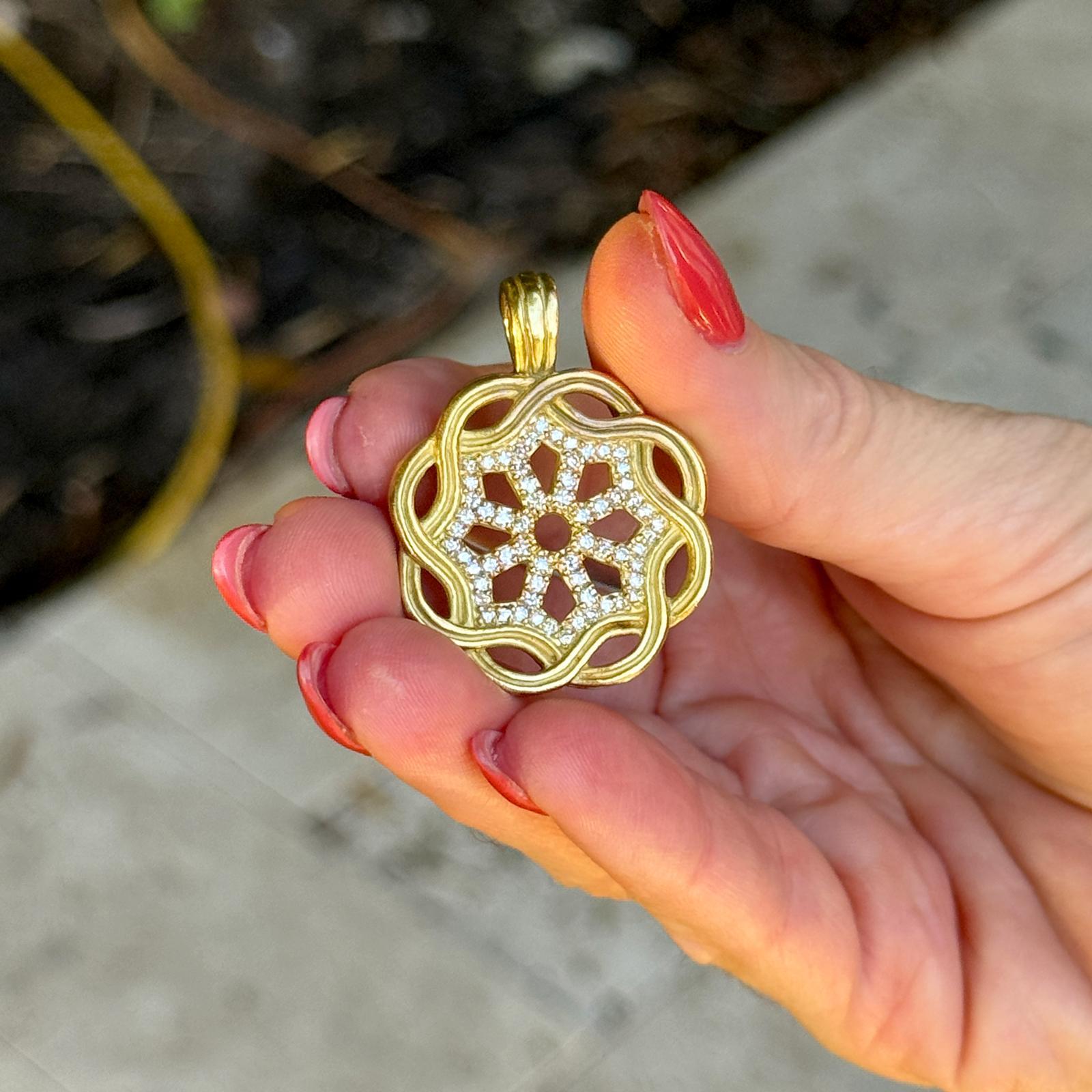 Issu de l'élégante collection Fenestra de Slane & Slane, ce pendentif enhancer en or jaune 18 carats présente un motif géométrique ouvert rehaussé de 56 diamants ronds de taille brillant totalisant environ 1,00 carat. Les diamants sont sertis de