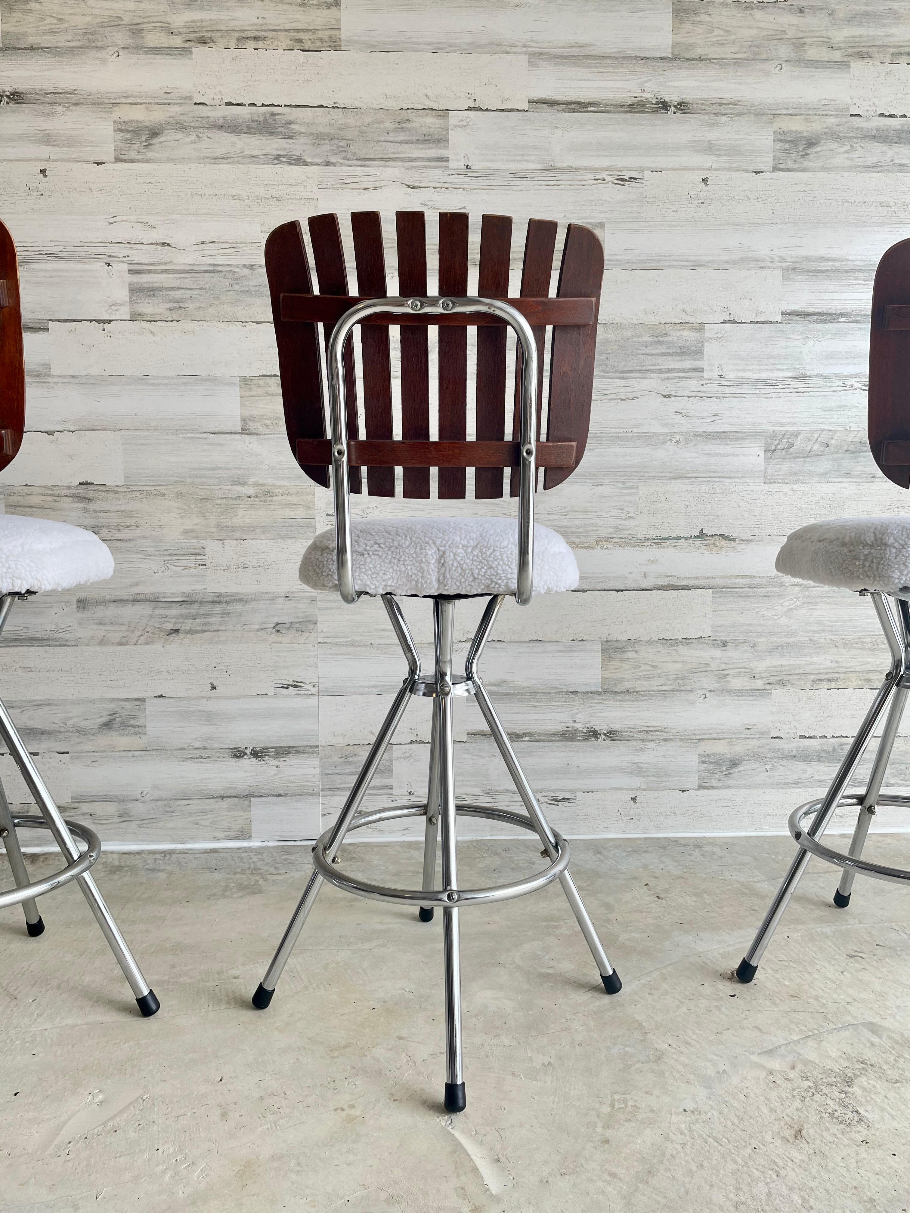 Wood slat back Arthur Umanoff style barstools with a fuzzy white Sherpa seat. Swivel metal base with new black rubber feet. Perfect for vintage modern style home.