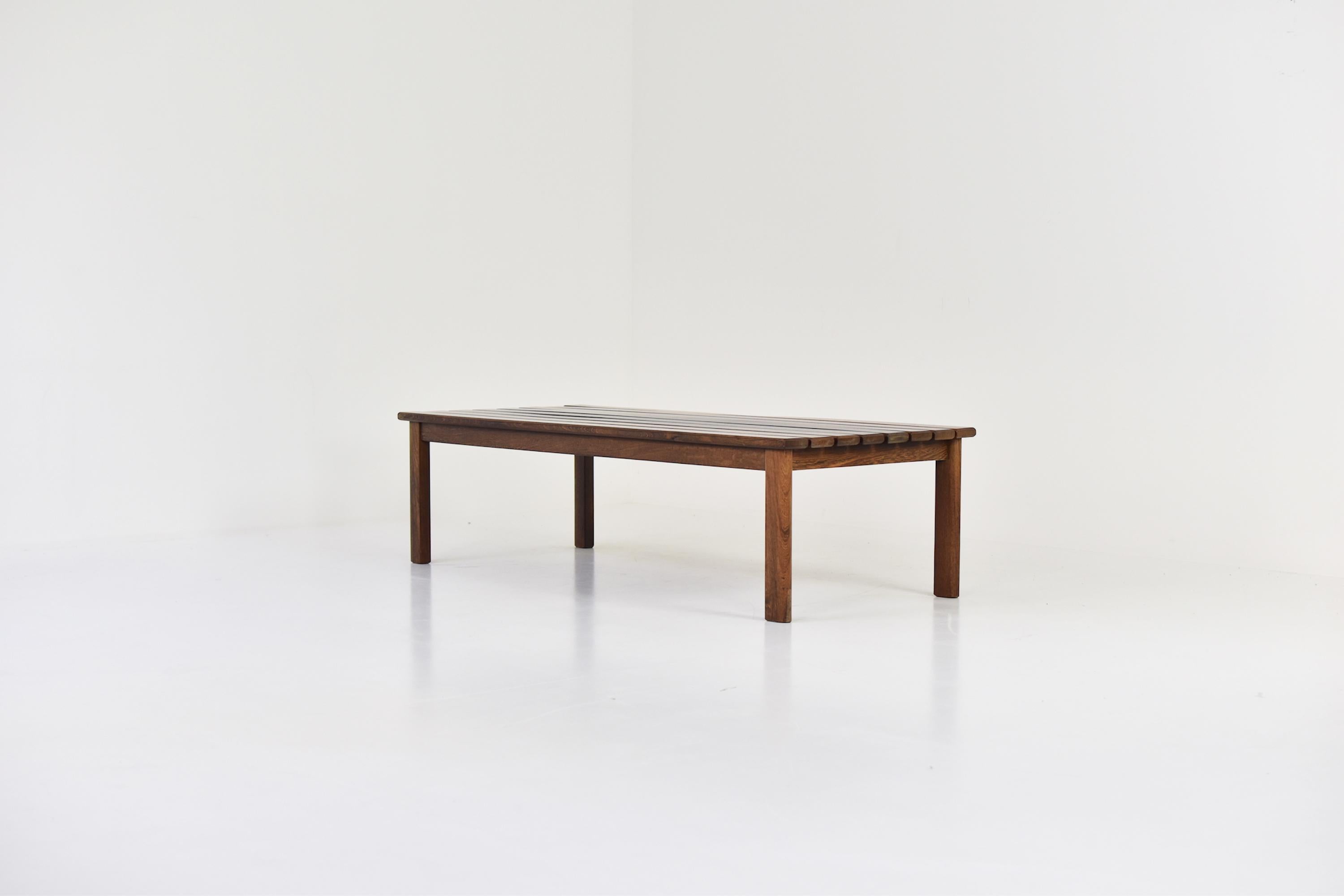 Slat bench or coffee table in stained ash for the seating and wenge wood for the legs, dating from the 1960’s. This bench has a modest design. Sophisticated but simple architectural structure which can easily fit in an inside or outside space.