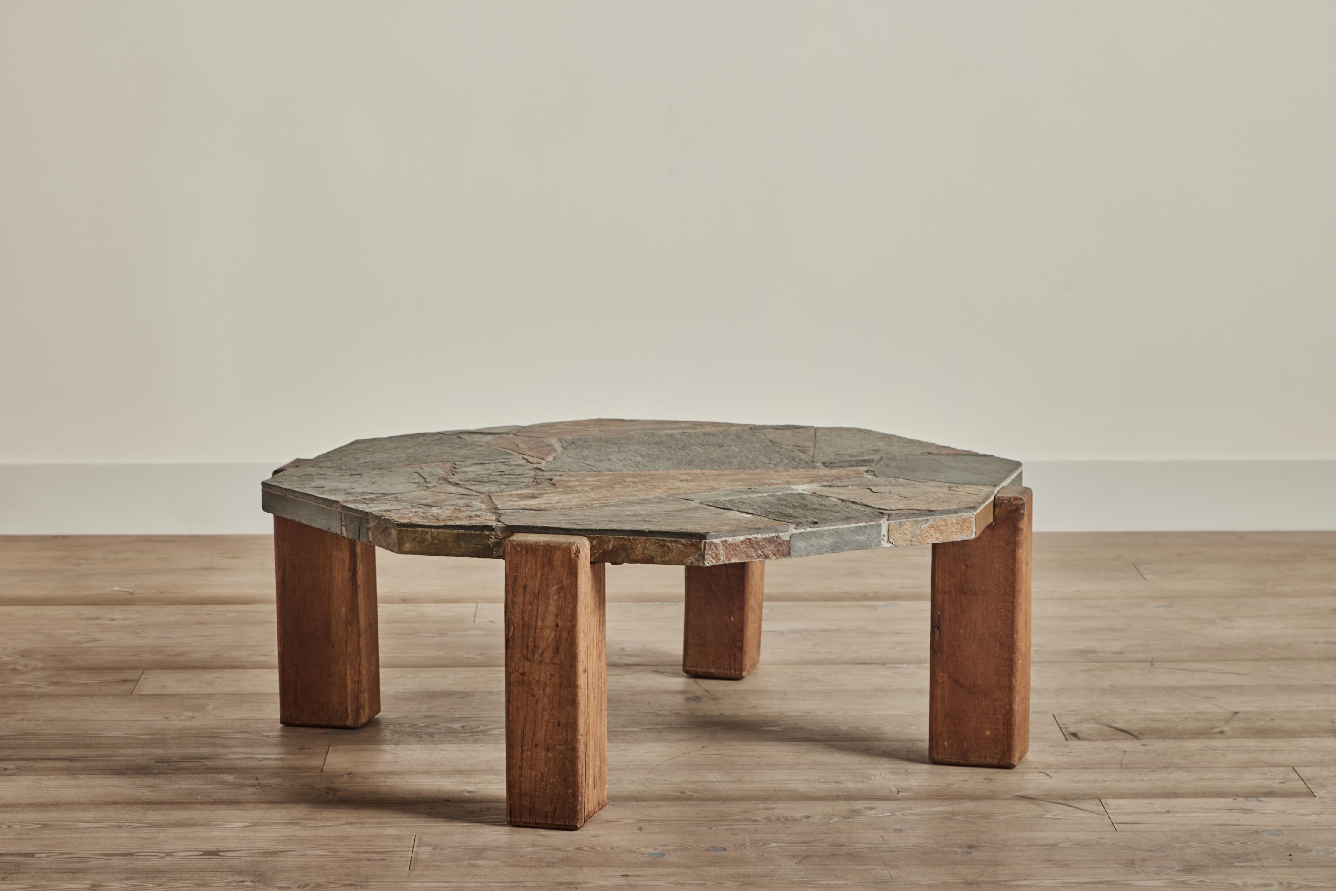 Table basse en ardoise du Danemark vers 1970. Cette table a un lourd plateau octogonal en mosaïque d'ardoise et des pieds en bois massif. L'usure de la table correspond à l'âge et à l'utilisation. 
