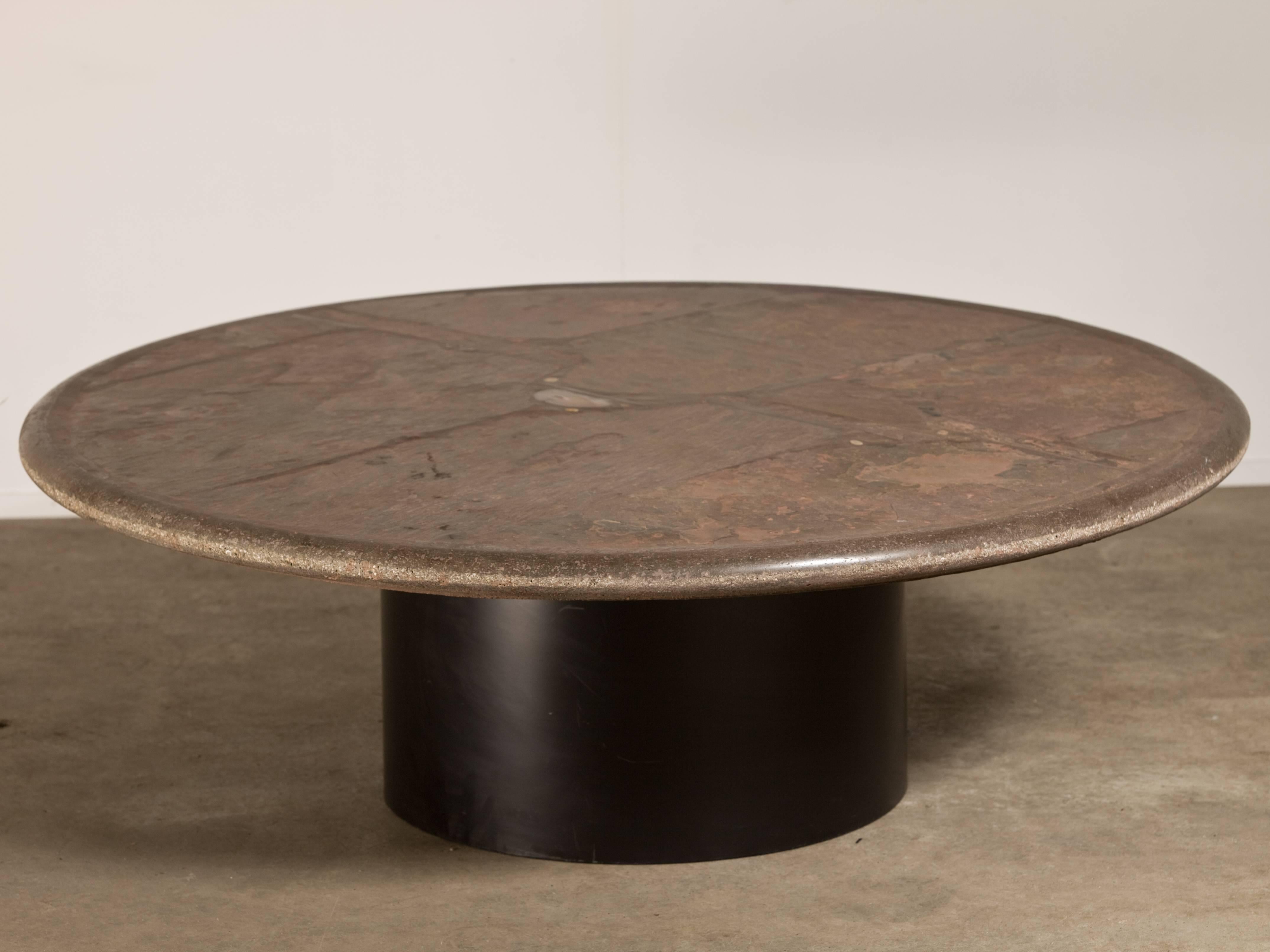 Beautiful slate stone coffee table by Paul Kingma -signed and dated 1989. This one has very nice soft pink shades and an inlay of various gem stones and copper pieces. The base that holds the top consists of a circle of black lacquered metal every