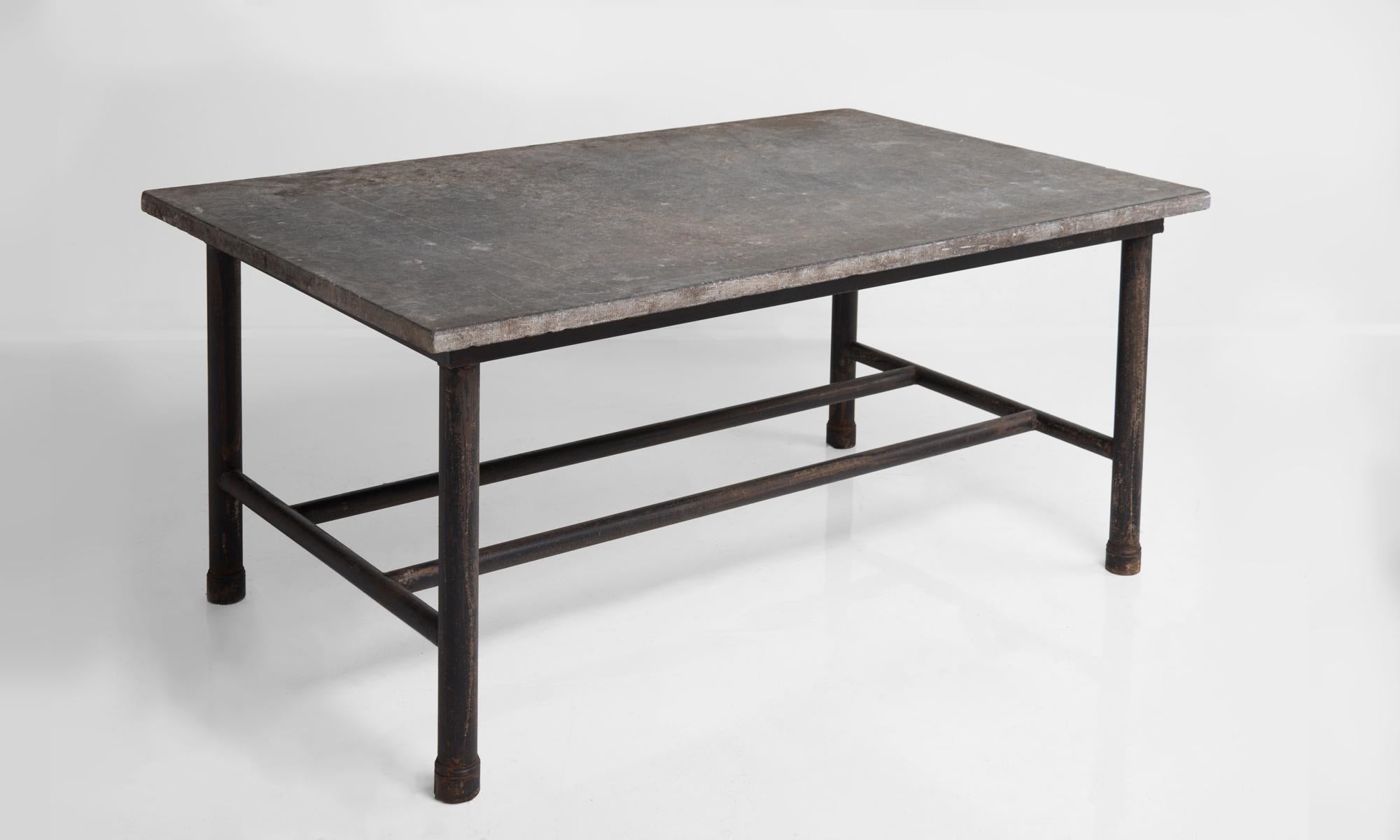 Slate top and metal work table, France, circa 1930.

Wonderful industrial form with cylindrical legs and stretchers and beautifully patinated stone top.