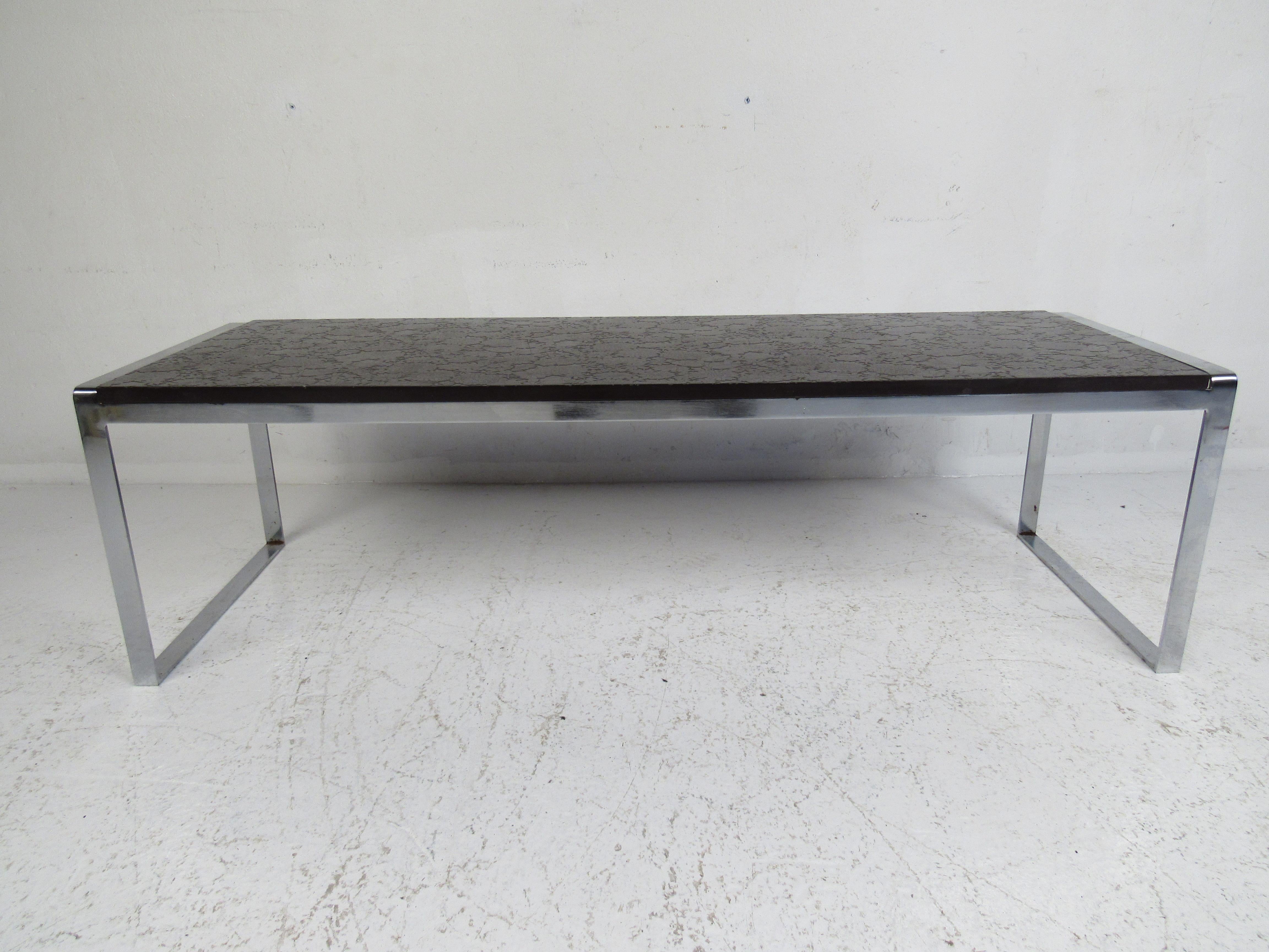 This beautiful vintage modern coffee table features a decorative slate top with etched floral designs. A sturdy and stylish flat bar chrome base adds to the midcentury appeal. The convenient rectangular design easily fits into any setting. Please