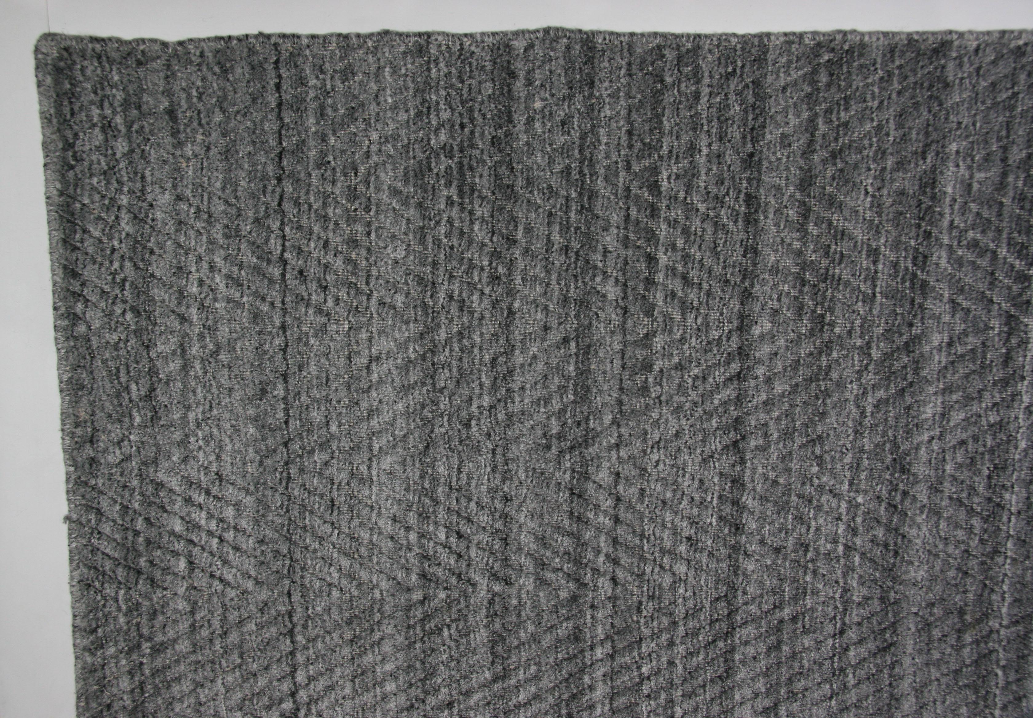 Texture e vivacità si uniscono in questo tappeto contemporaneo per la casa o l'ufficio moderno. L'altezza del pelo alto e basso crea un motivo a zig zag nei toni del grigio e dell'argento. L'annodatura a mano crea lati 