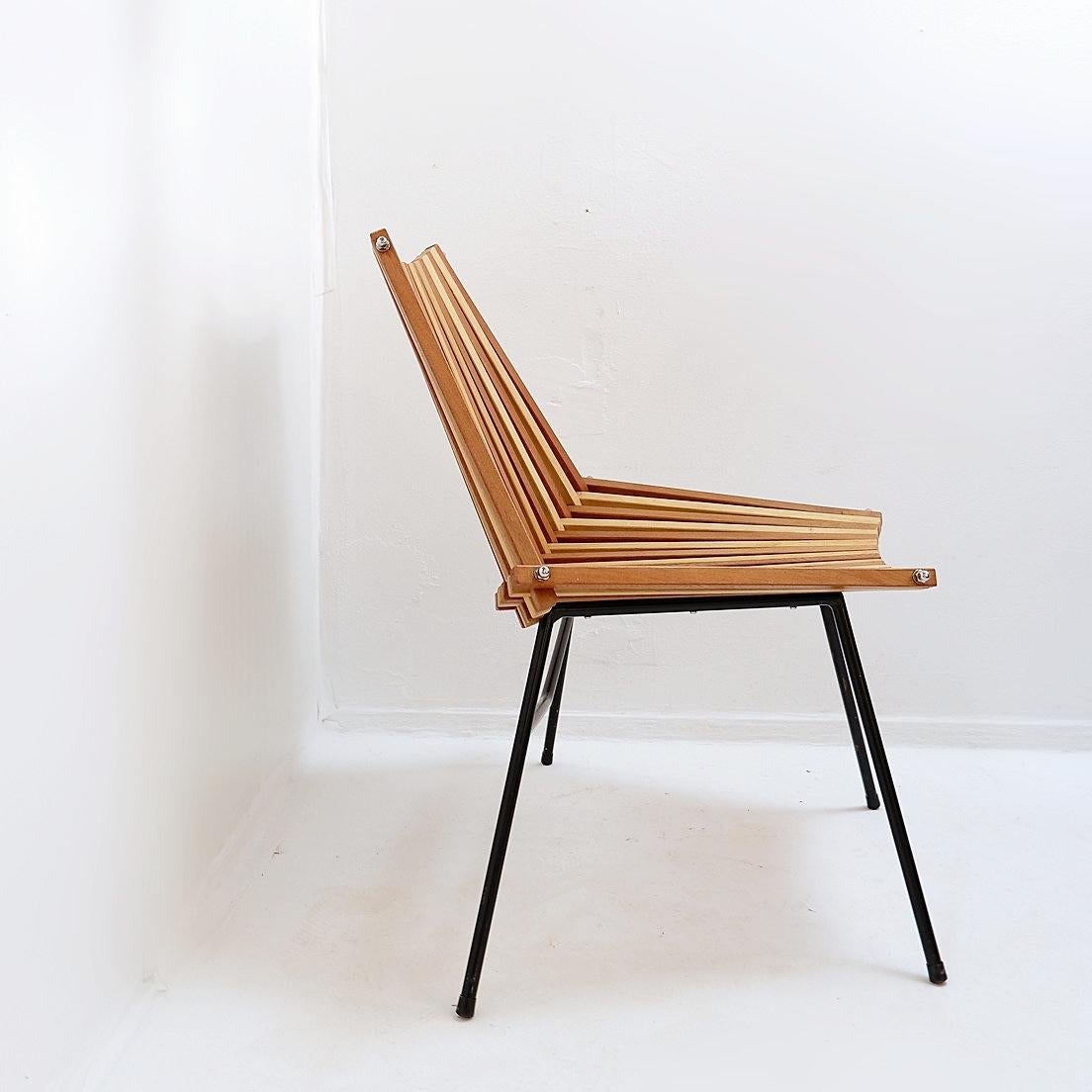 Vintage - Seating - Side Chair
Measures : 70x65 H:77cm SH:41cm 
Beautiful modernistic design with slats made from solid teak and birch which rest on a black metal frame. Two bolts on both sides hold the construction together. 