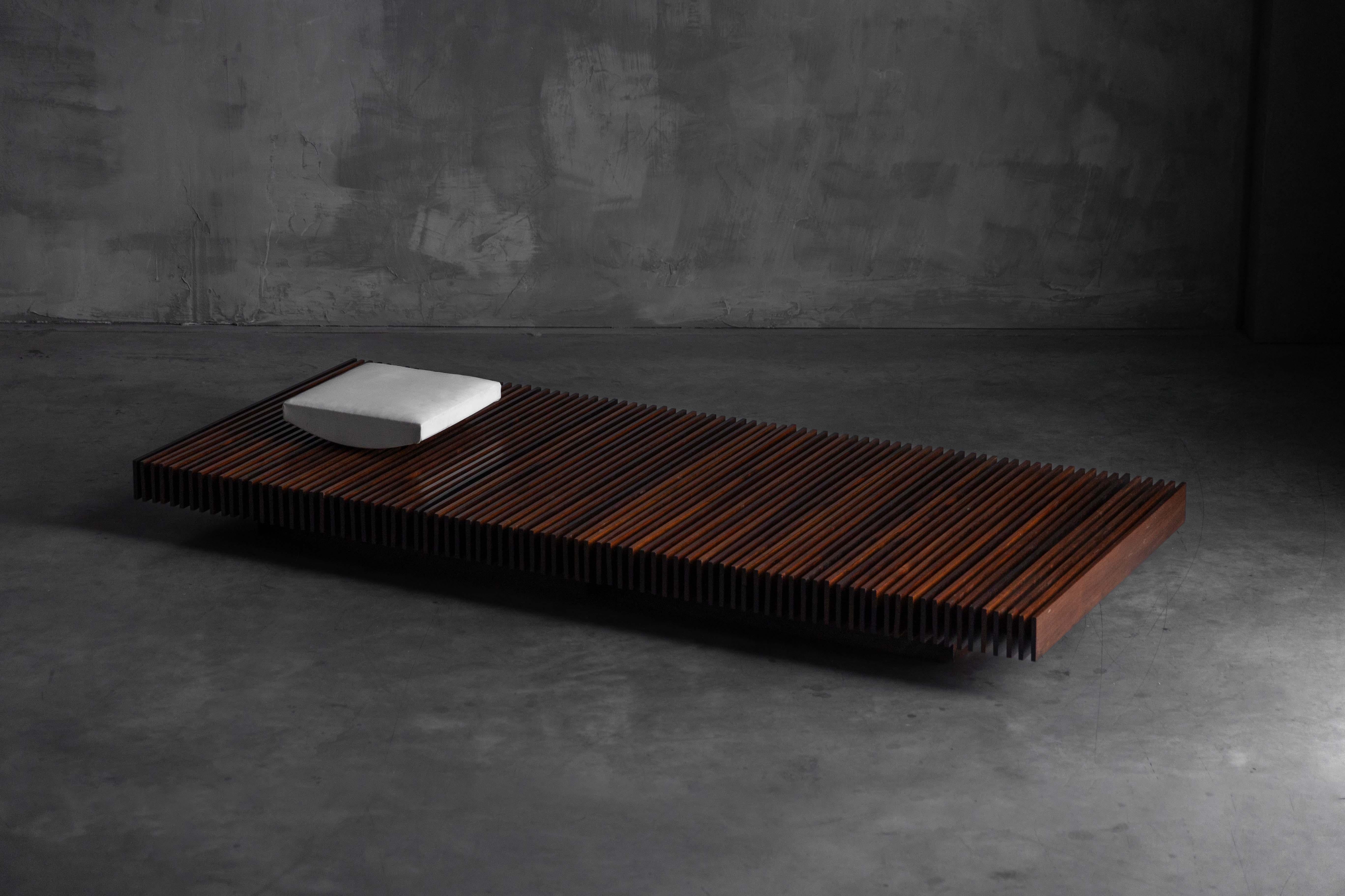 Ce banc à lattes en bois de jacaranda, fabriqué vers 1965 par Móveis Ambiente, est un exemple remarquable du design moderniste brésilien. Son origine est documentée dans le numéro de juin 1965 du magazine Casa & Jardim. Le banc est composé de lattes
