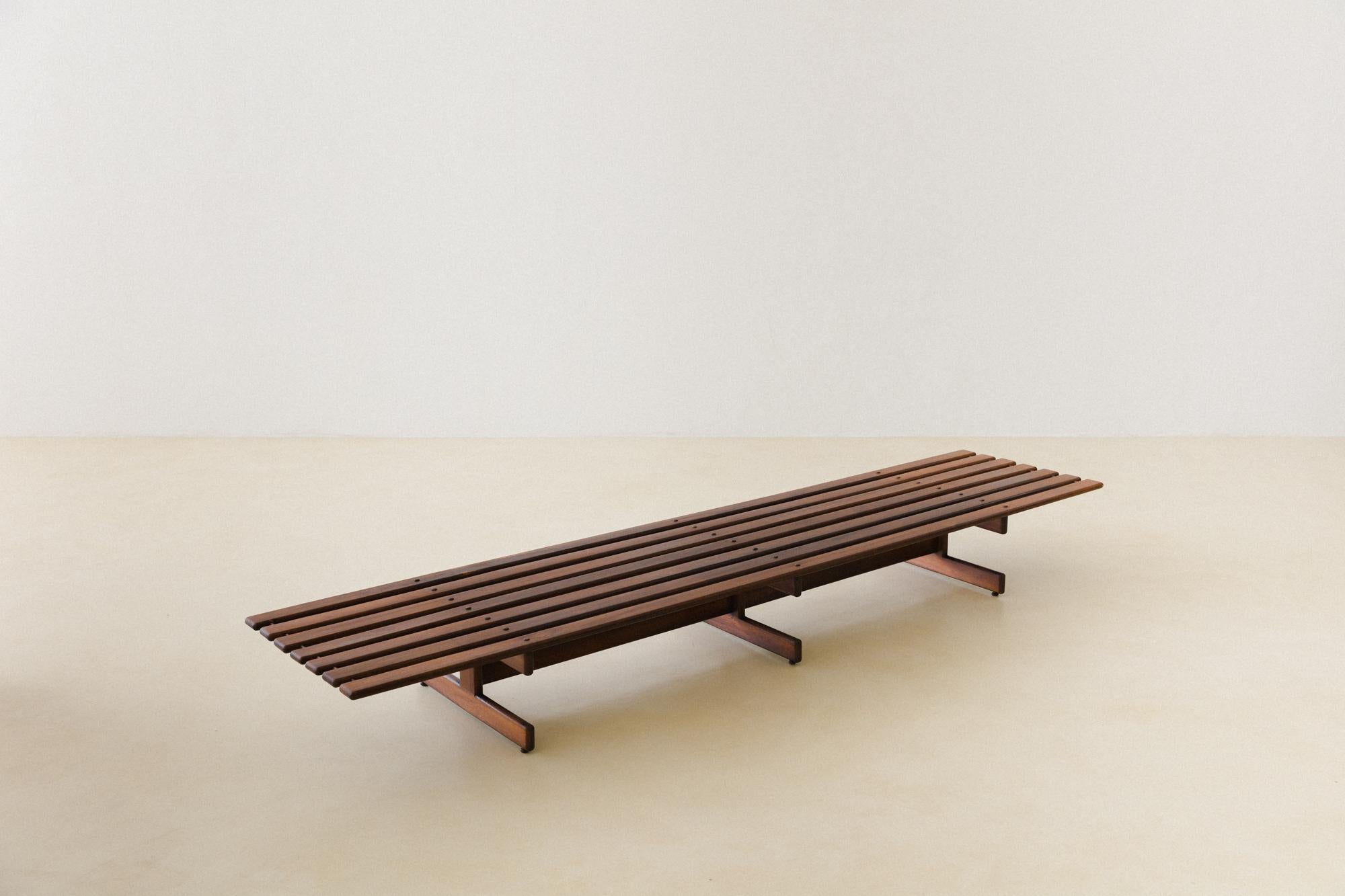 This gorgeous bench was produced by Cantù Móveis e Interiores LTDA. in the 1960s. It consists of a very well-constructed piece in solid Rosewood, with slats rhythmically positioned supported by three feet with the characteristic shape used by the