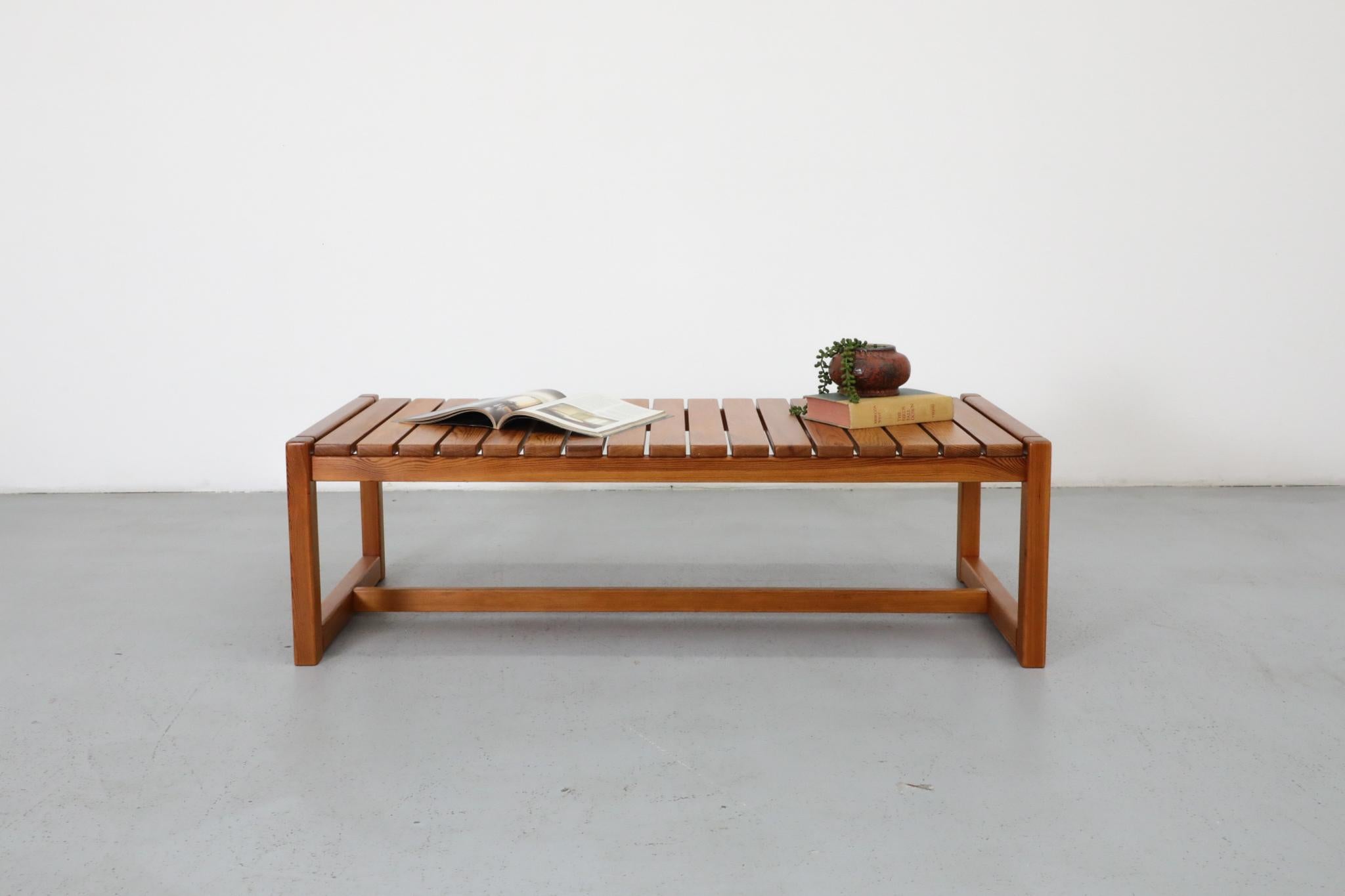 Table basse ou banc minimaliste en pin du milieu du siècle, conçu dans le style du designer finlandais Ilmari Tapiovaara. Le plateau à lattes et les pieds carrés reflètent les lignes épurées et fonctionnelles typiques du design Modern Scandinavian.
