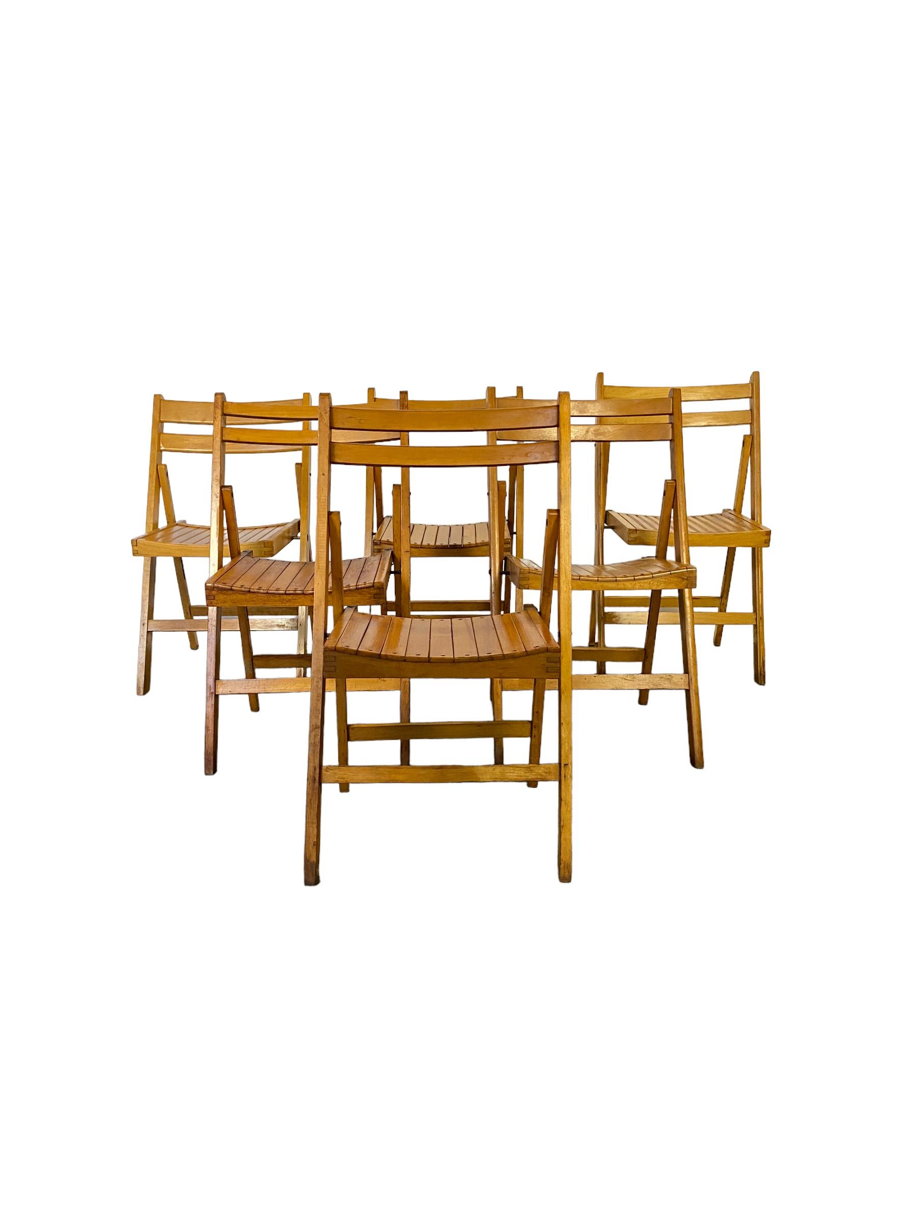 Set of six vintage mid century wood folding chairs with slatted wood seats. Good vintage condition with minor wear consistent with use. Easy to fold and compact for storage when not in use. Made in Yugoslavia. Four are exact matches and a pair of