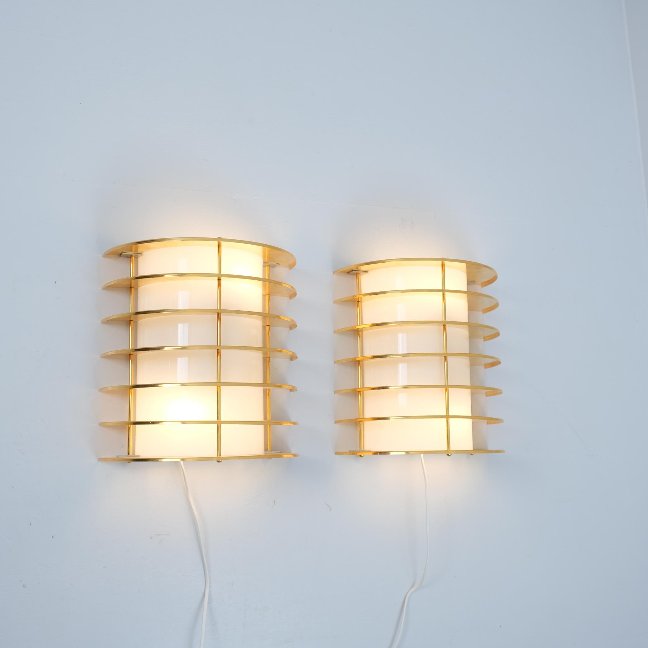 Magnifique applique demi-circulaire moderniste en laiton et acrylique. Le design/One élégant permet à la lumière de circuler latéralement ainsi que vers le haut et le bas à travers les ouvertures supérieures et inférieures. Chaque lampe est équipée