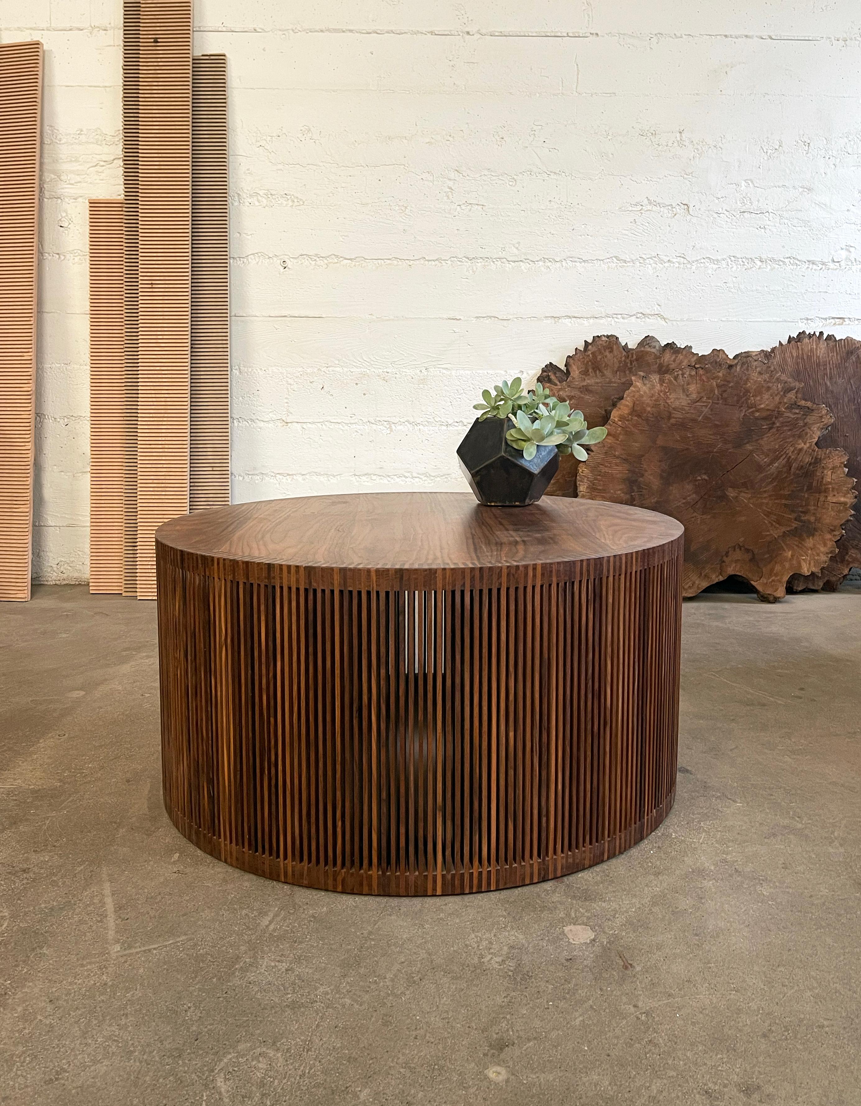Exquisitely detailed coffee table made from solid walnut. A simple round top and bottom panels joined by a vertical walnut screen that is both modern and warm.

This piece is visually striking, offering richness  and depth to a space. Standard size