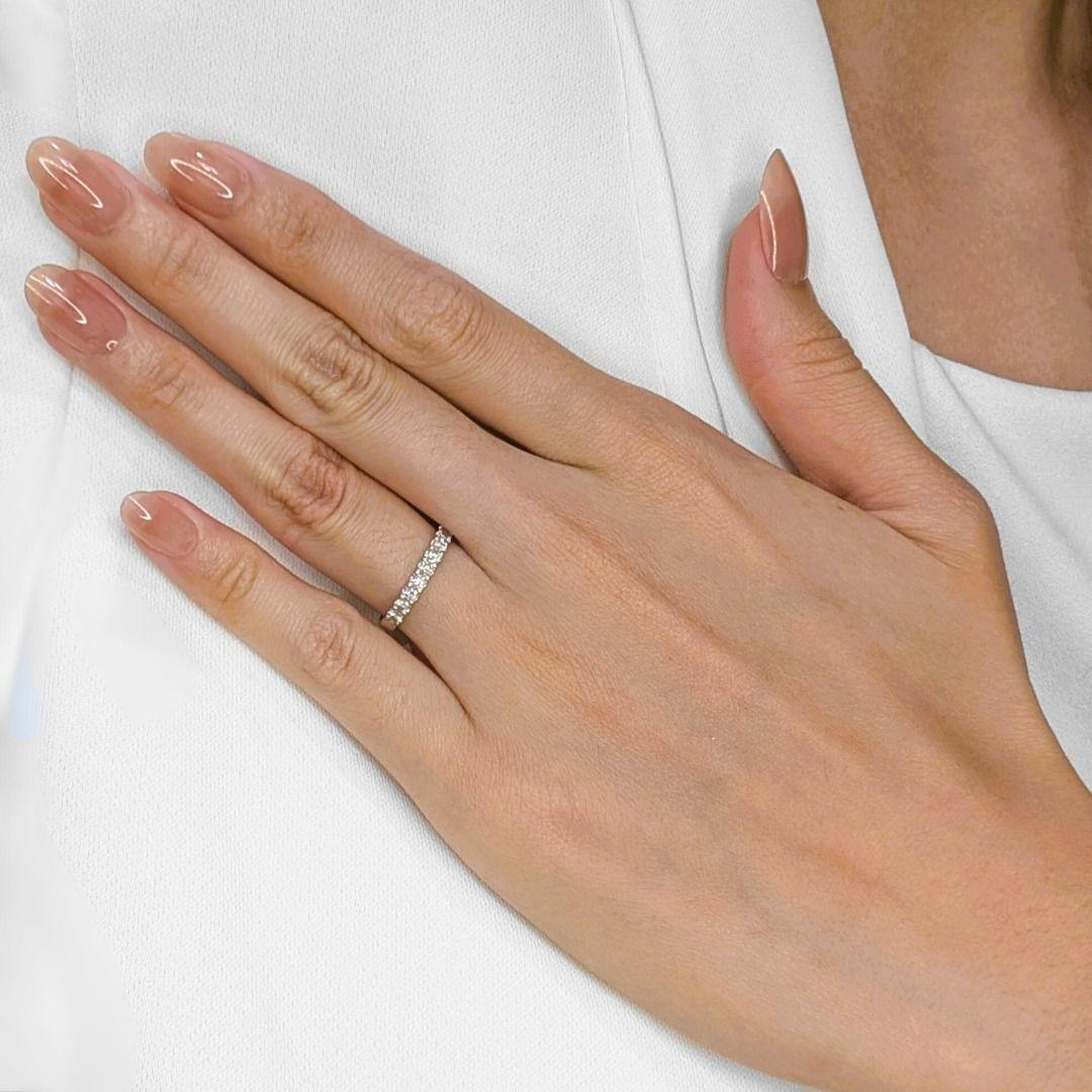 Un chuchotement d'étincelles, une bande délicate fabriquée par Gold Heart, prête à ajouter une touche d'élégance discrète à votre collection. Cette bague d'occasion en or blanc 18 carats est ornée de neuf diamants ronds de taille brillant, d'une