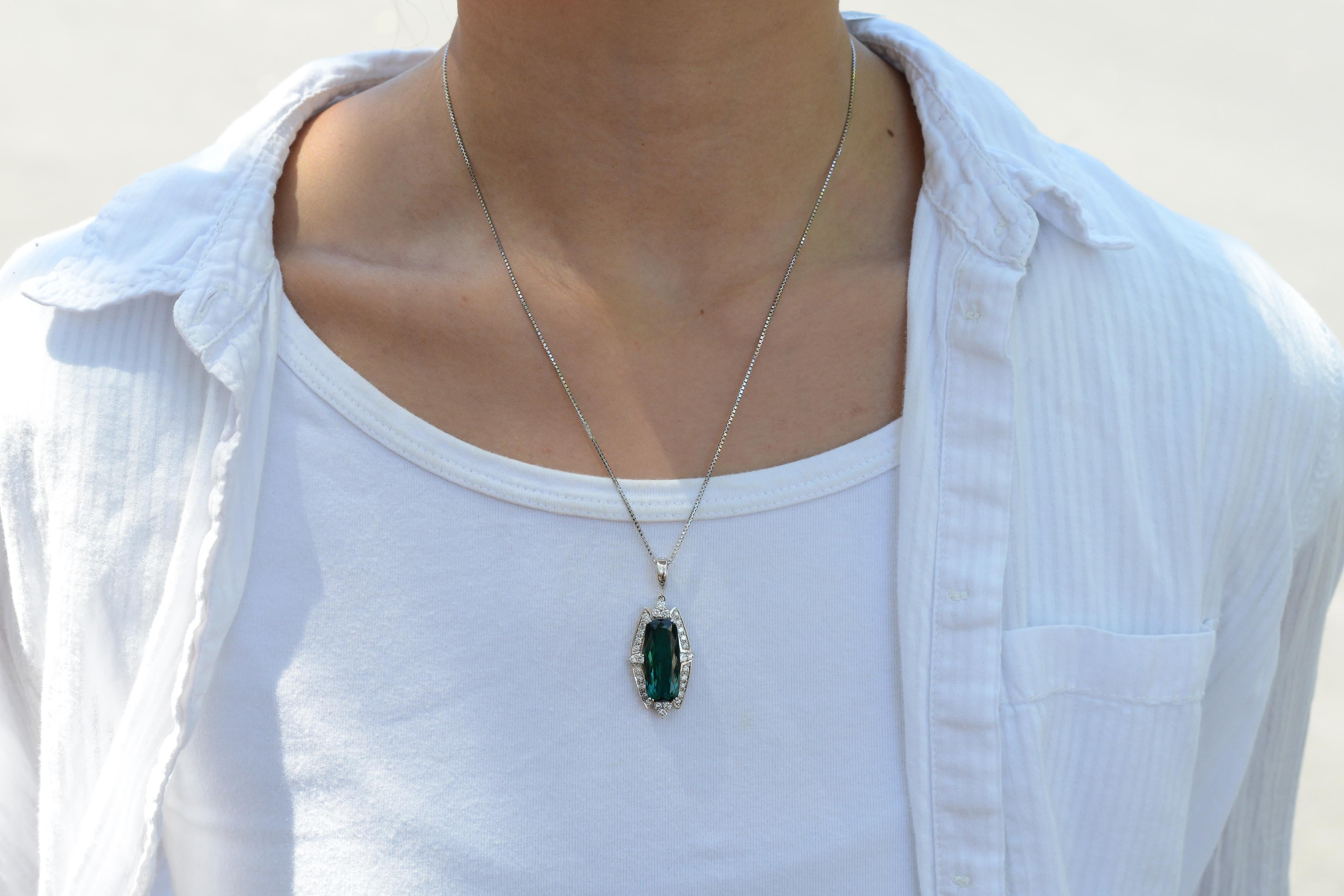 A classic contemporary pendant necklace presenting a transfixing 10.16 carat tourmaline set with lavish platinum. Its north-south design renders a balanced statement, while a mesmerizing bluish-green indicolite tourmaline with a Paraiba tone,