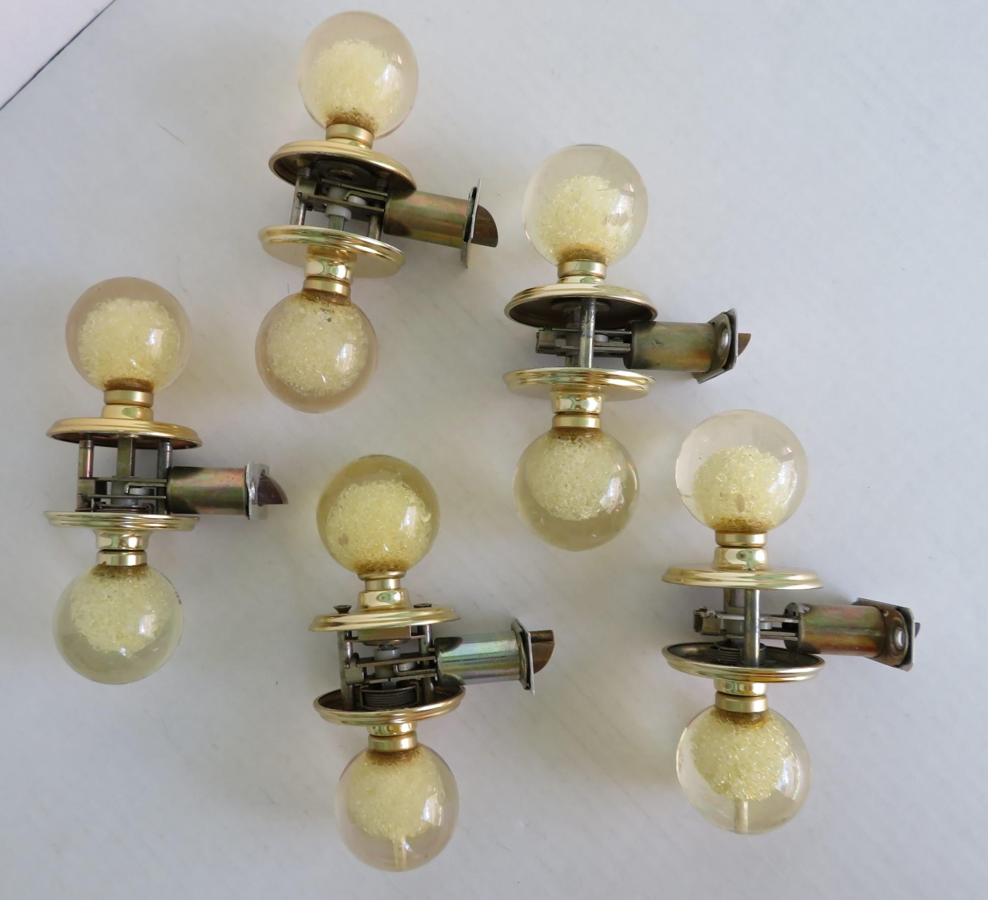 A Luxe set of five Lucite door handles knobs with bubbly inclusions by interior designer, architect and home builder Ruth Richmond of Sarasota, Florida. With dark brass mounts, the slightly amber Lucite balls have interior explosions of bubbles