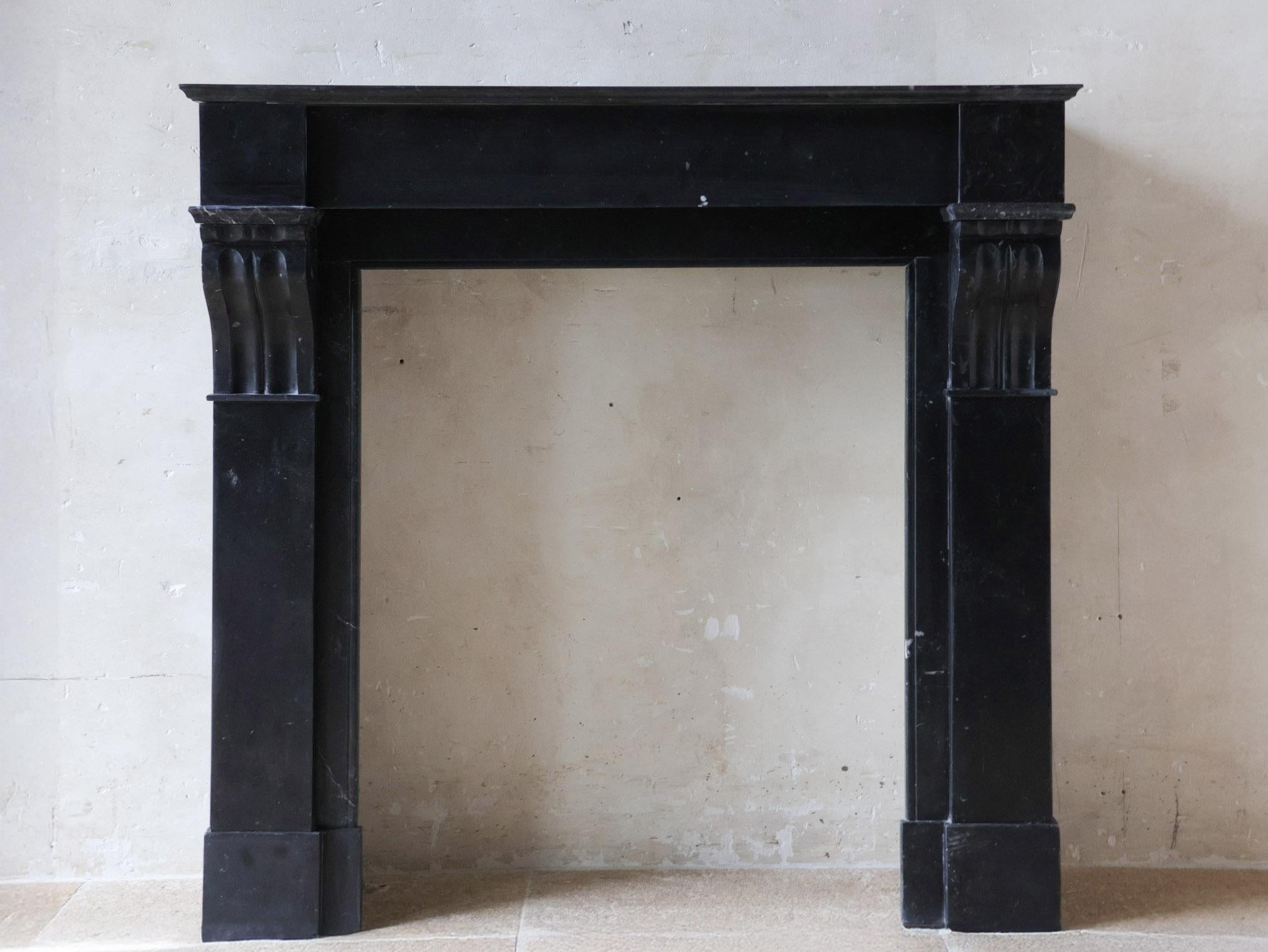 Cheminée élégante en marbre noir ancien, modèle Modillion, datant du début du 20e siècle. Petite taille. Cheminée hollandaise de style Amsterdam, réalisée en marbre Noire de Nasy, une couleur typiquement hollandaise qui était couramment utilisée