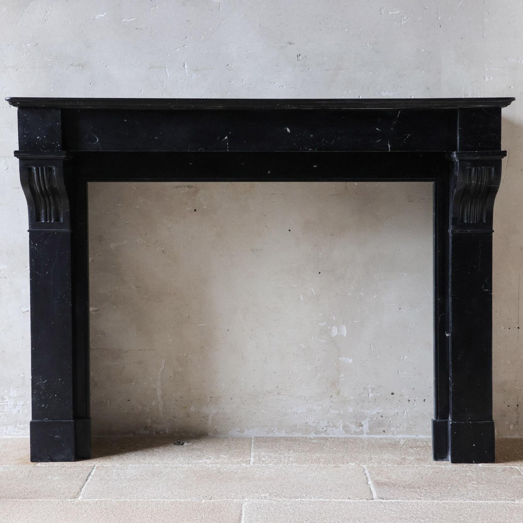 Cheminée élégante en marbre noir ancien, modèle Modillion, datant du début du 20e siècle. Cheminée hollandaise de style Amsterdam, réalisée en marbre Noire de Nasy, un marbre noir avec des veines sublimes, une couleur typiquement hollandaise qui