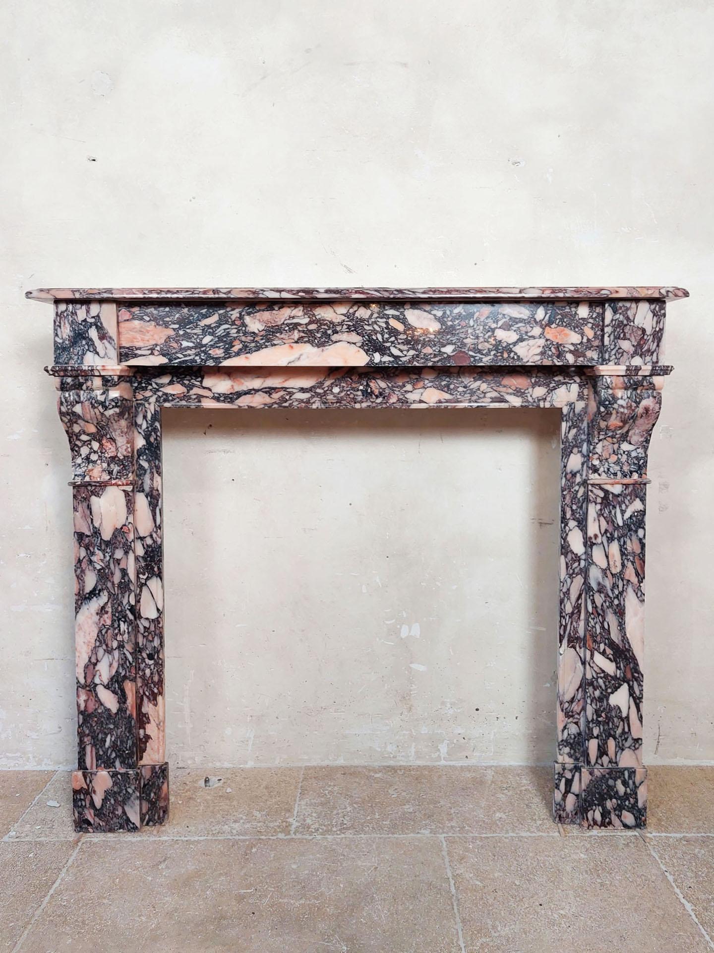 Sleek antique modillion mantelpiece made of breche violet marble. An exclusive marble in pink and violet tones that was usually used for much richer mantelpieces or objects because it is traditionally one of the more valuable types of marble. A