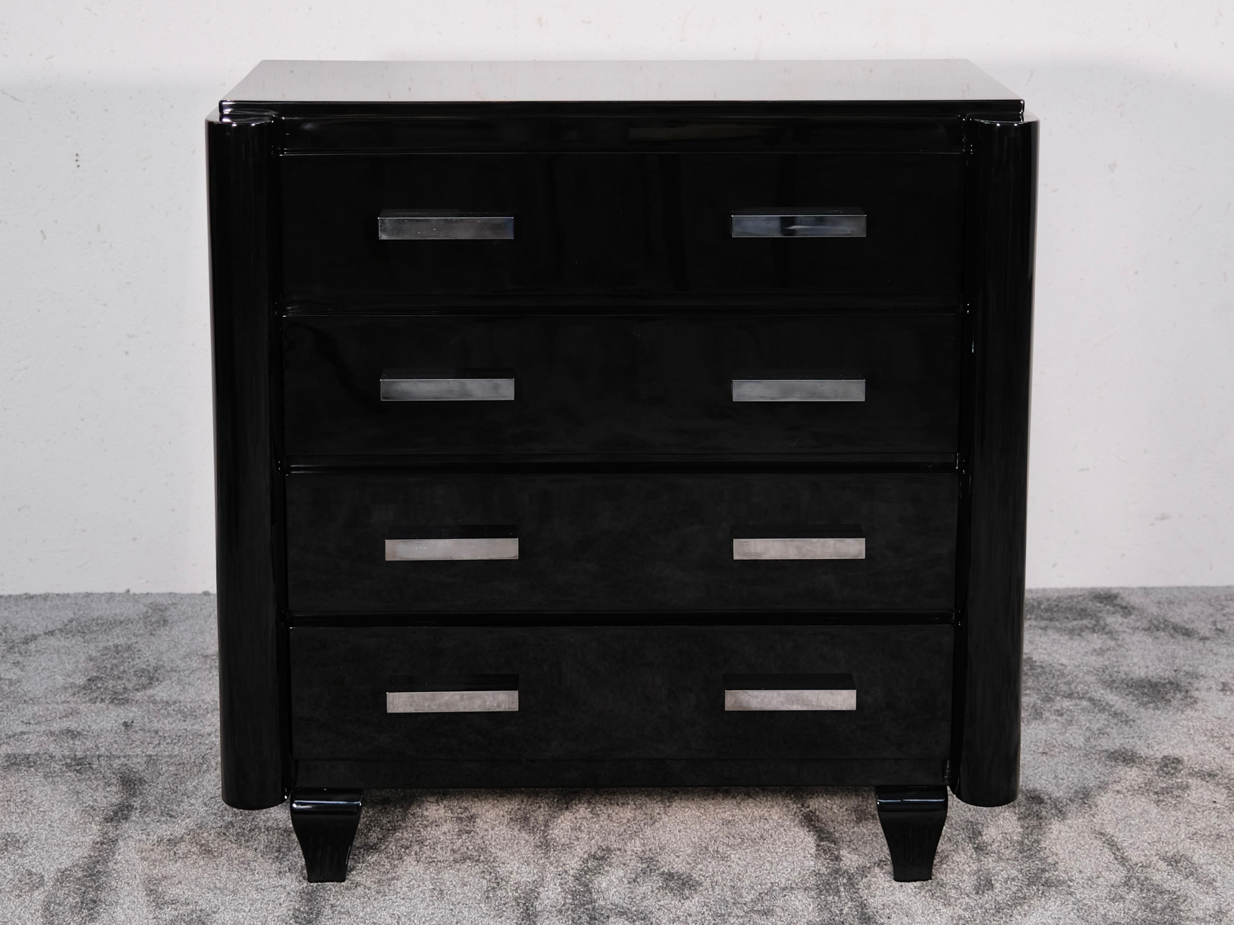 Art Deco Kommode aus schwarzem Lack - Elegant, architektonisch, raffiniert

Diese auffällige Kommode im Art-Déco-Stil zelebriert Symmetrie und modernistische Geometrie und ist in den tiefen, spiegelnden Glanz von schwarzem Hochglanz-Klavierlack