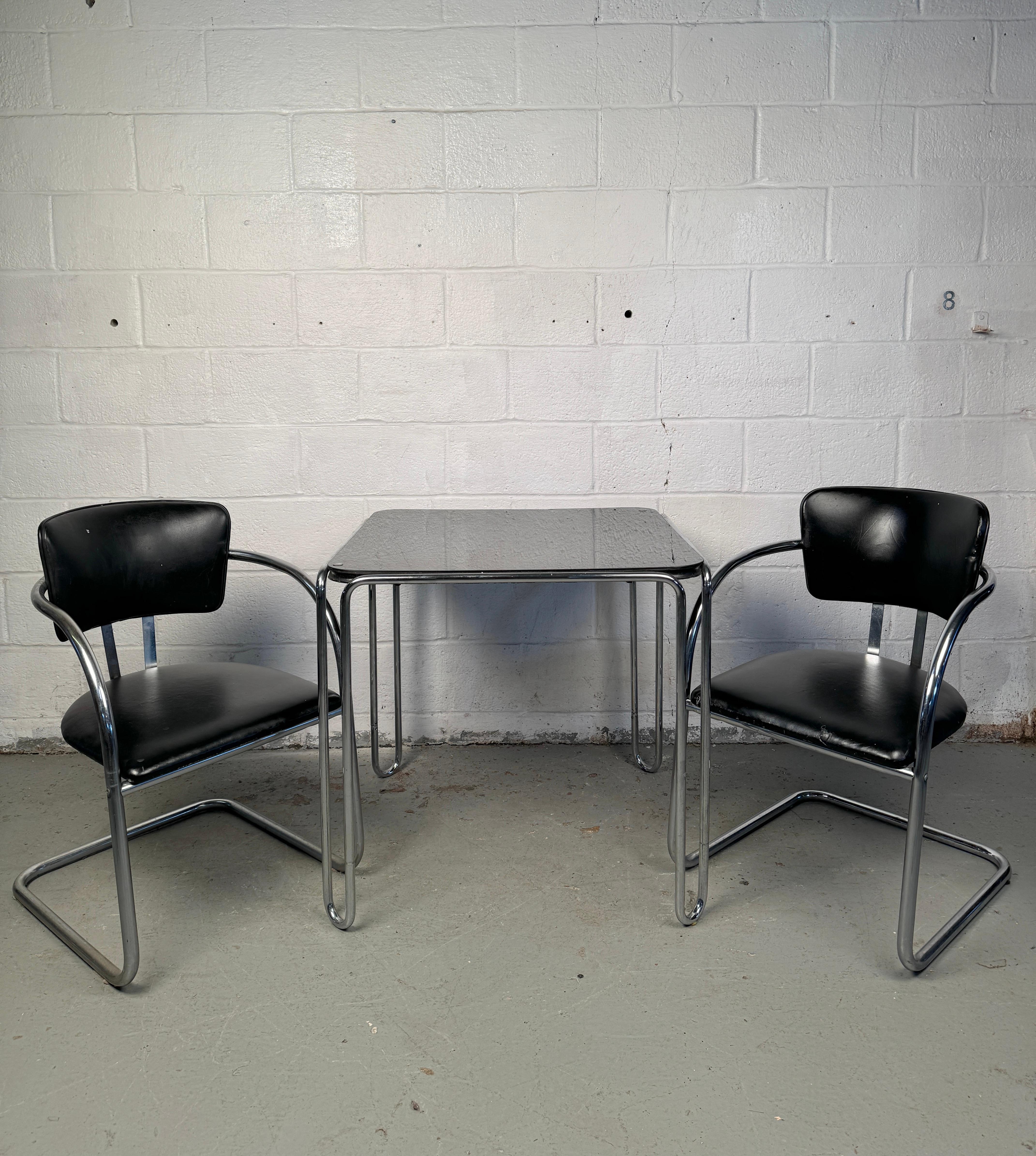 Apportez une fusion rare de design historique et d'élégance moderniste dans votre espace avec cet ensemble vintage époustouflant. En son cœur se trouve l'emblématique table 