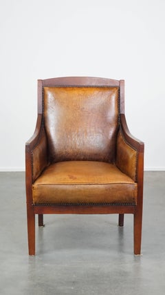 Elegante, bellissima poltrona vintage in pelle di pecora e legno dal design Art Déco