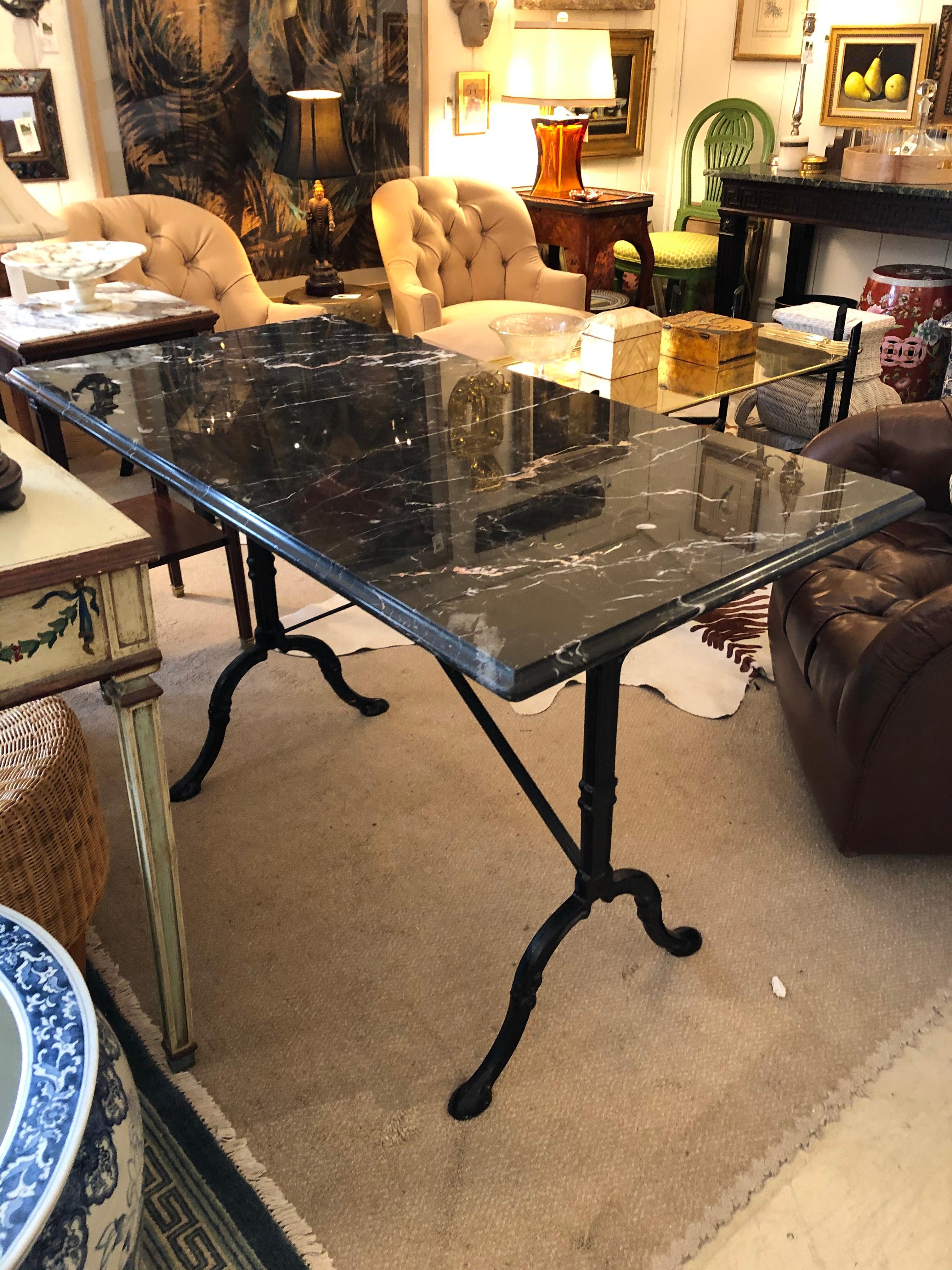 A versatile rectangular console, writing table or desk having glamorous black and white marble beveled top on top of wrought iron base with two Y-shaped legs, stretcher and cabriole legs.