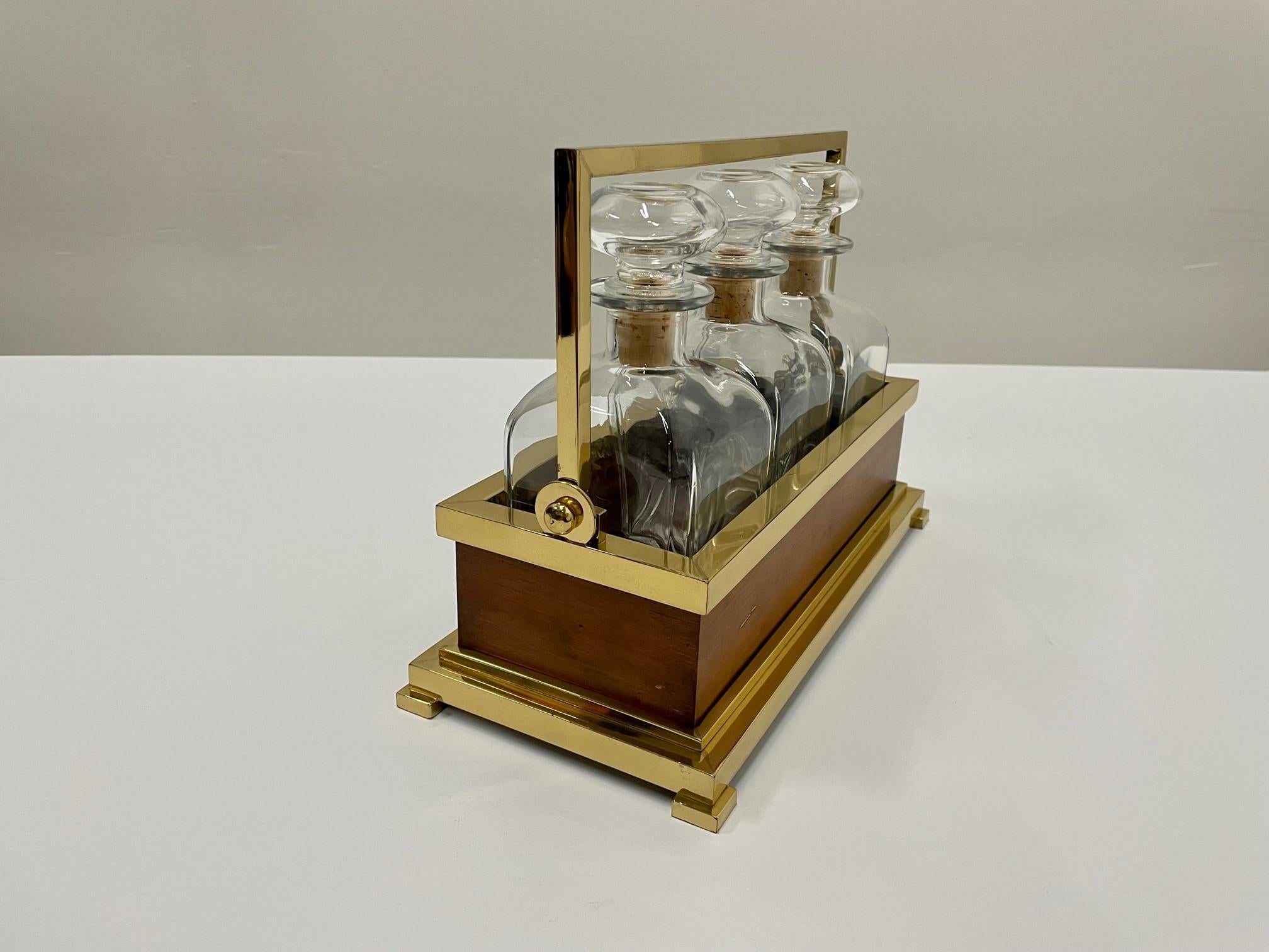 Luxurious mahogany and brass tantalus holding 3 glass liquor decanters with working lock mechanism and key.