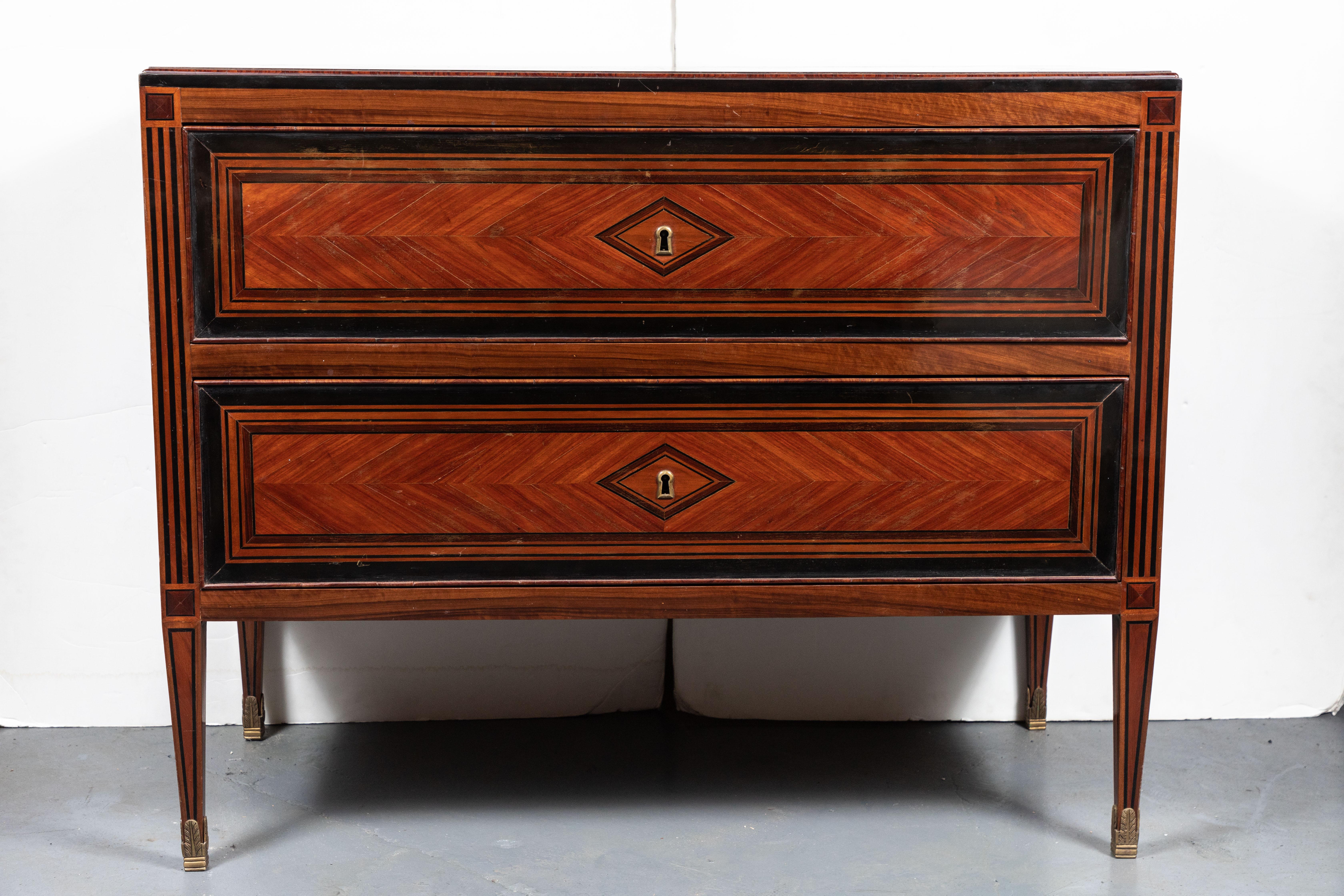 Beautiful, 19th century, inlaid, Tuscan commode in cherry and ebonized wood, fully decorated on three sides. Geometric patterning frame both drawers with a diamond surrounding the escutcheons. The whole on tapered legs.