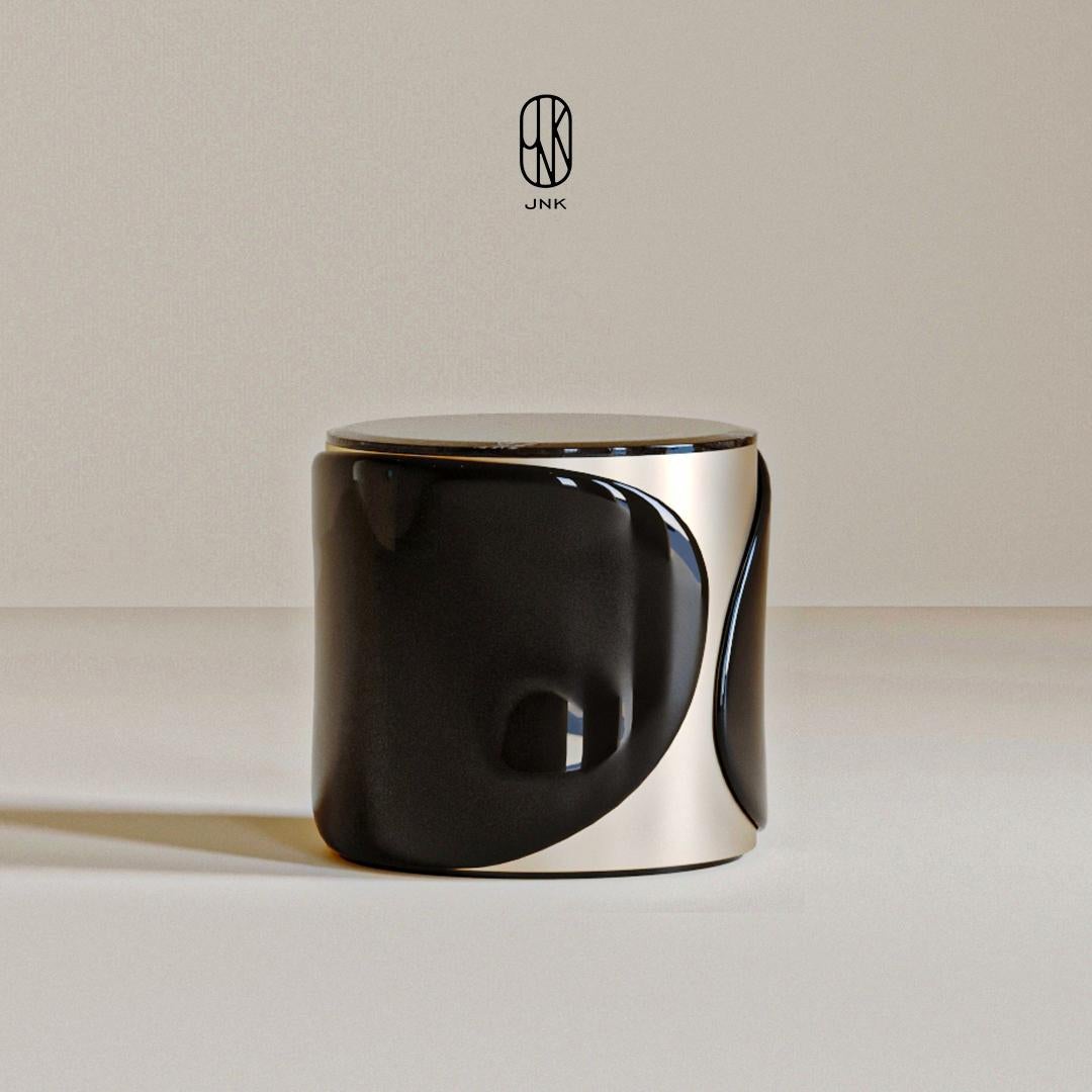 Table de nuit Torres, 

Elle présente un design moderne et minimaliste. Sa forme ronde présente une combinaison élégante de tons noir brillant et argent métallique. La surface de la table de nuit présente un élégant jeu de noir et d'argent, les