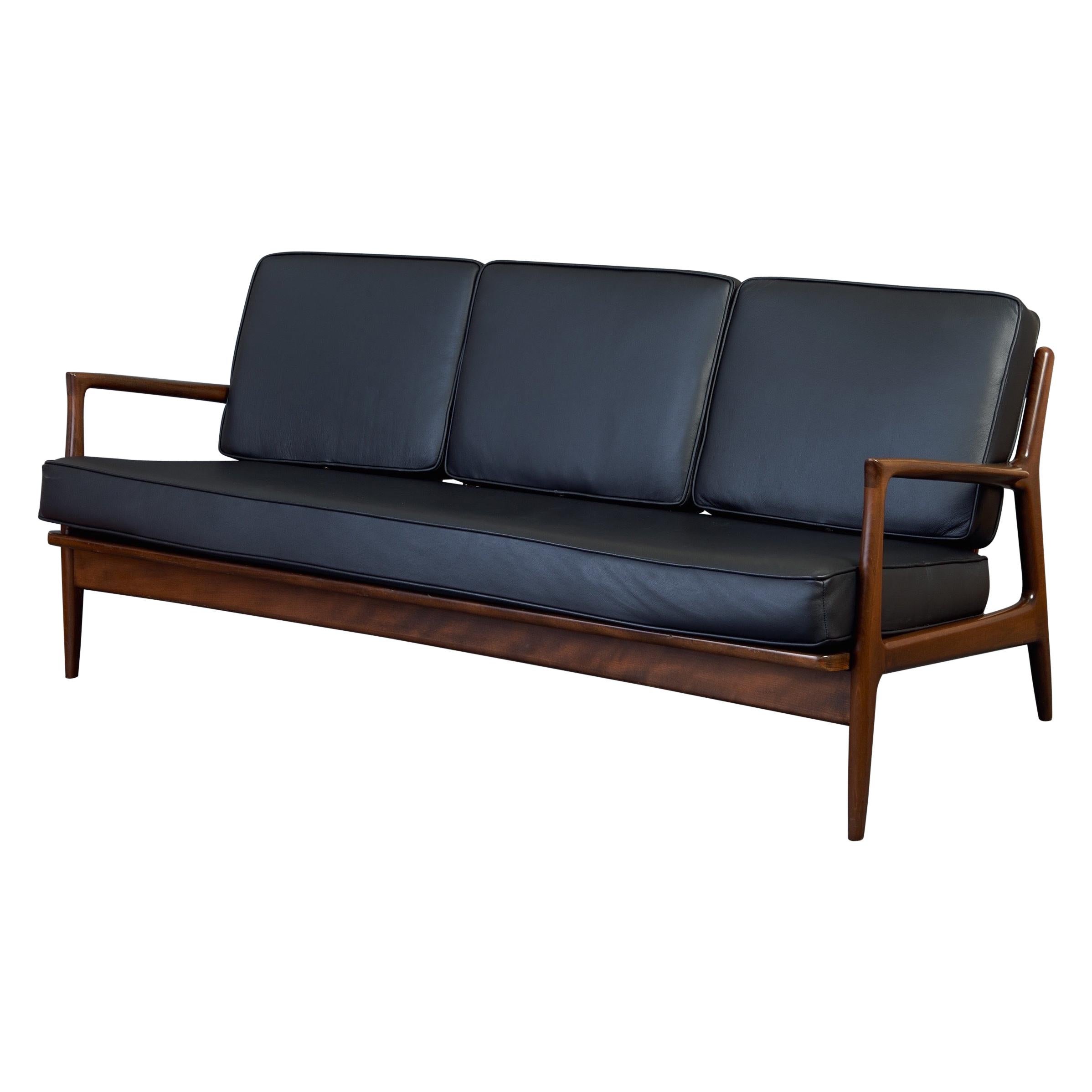 Elegantes modernes dänisches Sofa von Ib Kofod-Larsen aus Teakholz und schwarzem Leder, 1950er Jahre im Angebot