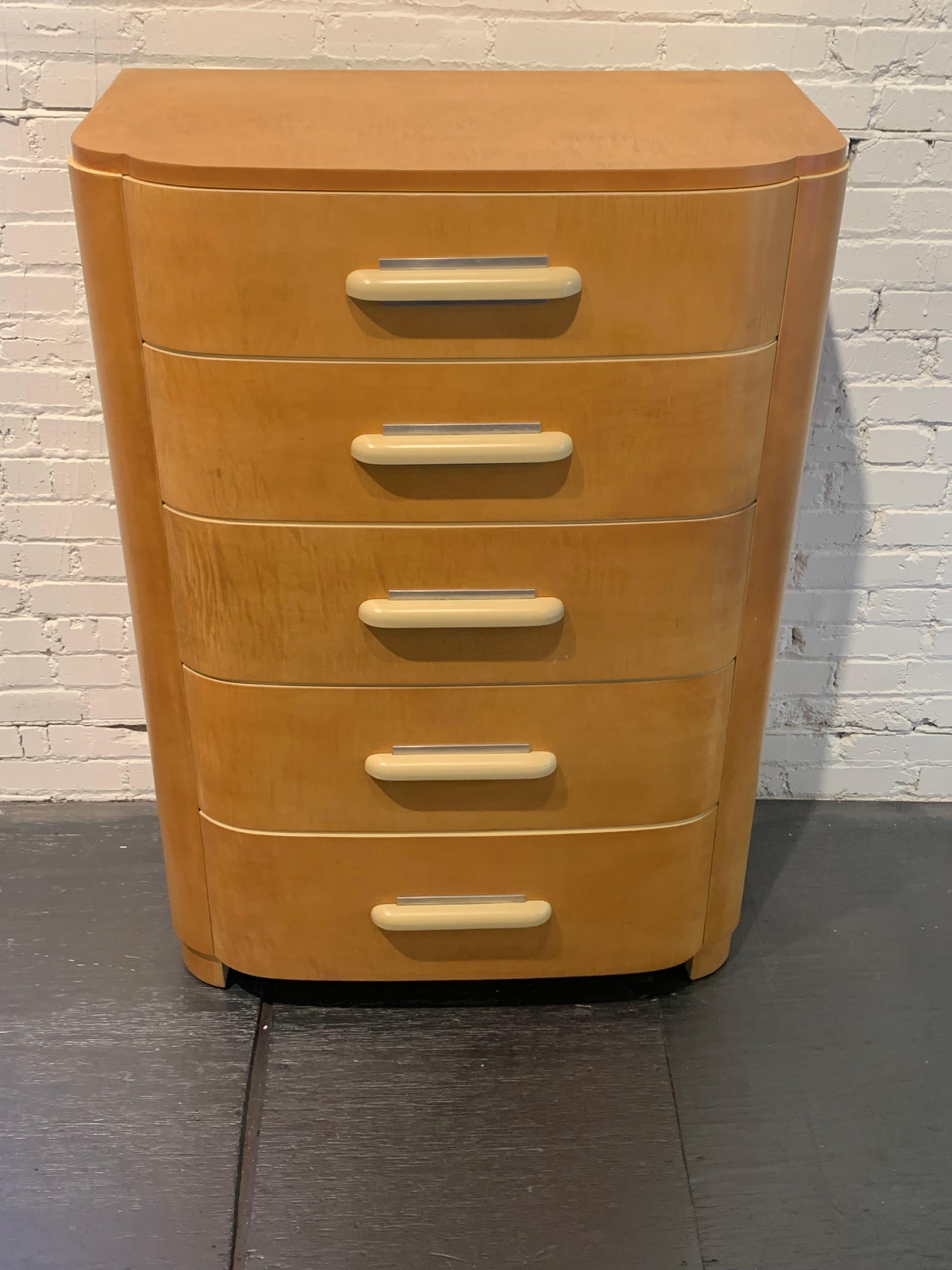 Wonderful period streamline Art Deco design highboy dresser by Donald Deskey (1894-1989) for Widdicomb furniture in maple veneer and aluminum details. Cream lacquered handles and highlights. Older restoration, saw very little use since restored,