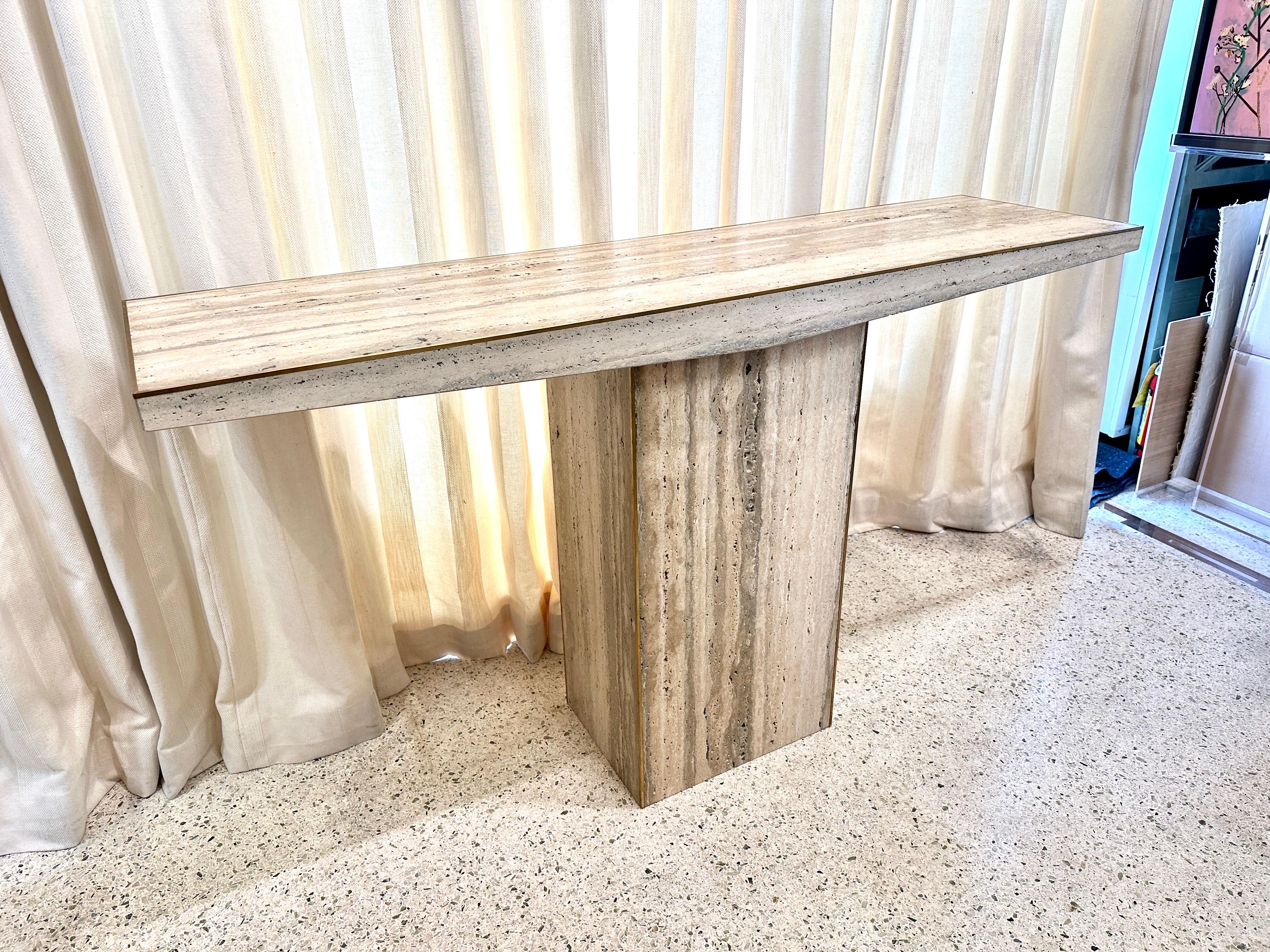 We have TWO wonderful Italian unfilled travertine console tables with a thin decorative brass trim around top and base.  Geometric design, simple and elegant.