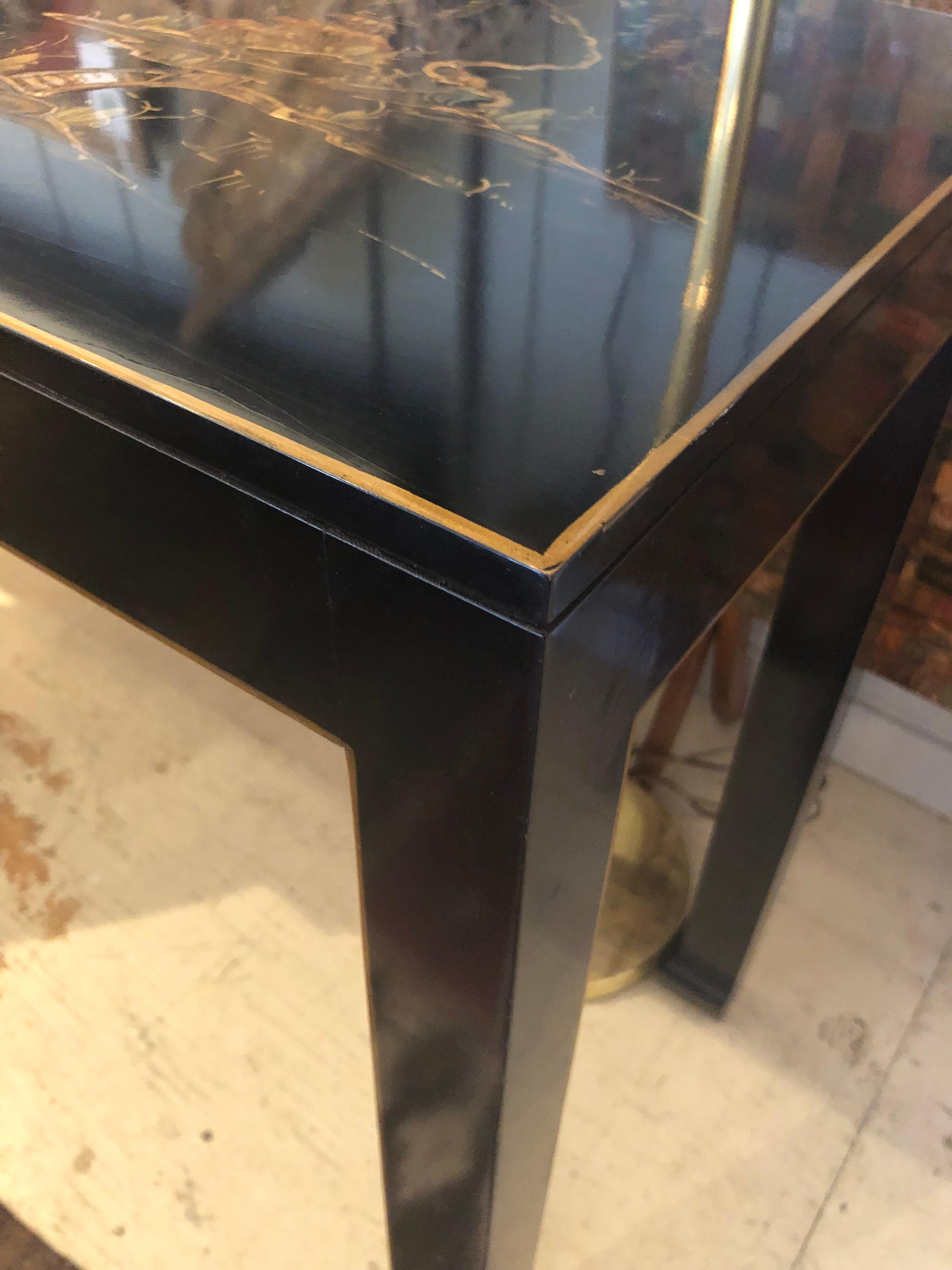 Sleek black lacquer 5 ft long narrow console or sofa table having lovely Japanese decoration on top with figures, pagodas, boats and bridges.  The legs have classic Asian form.