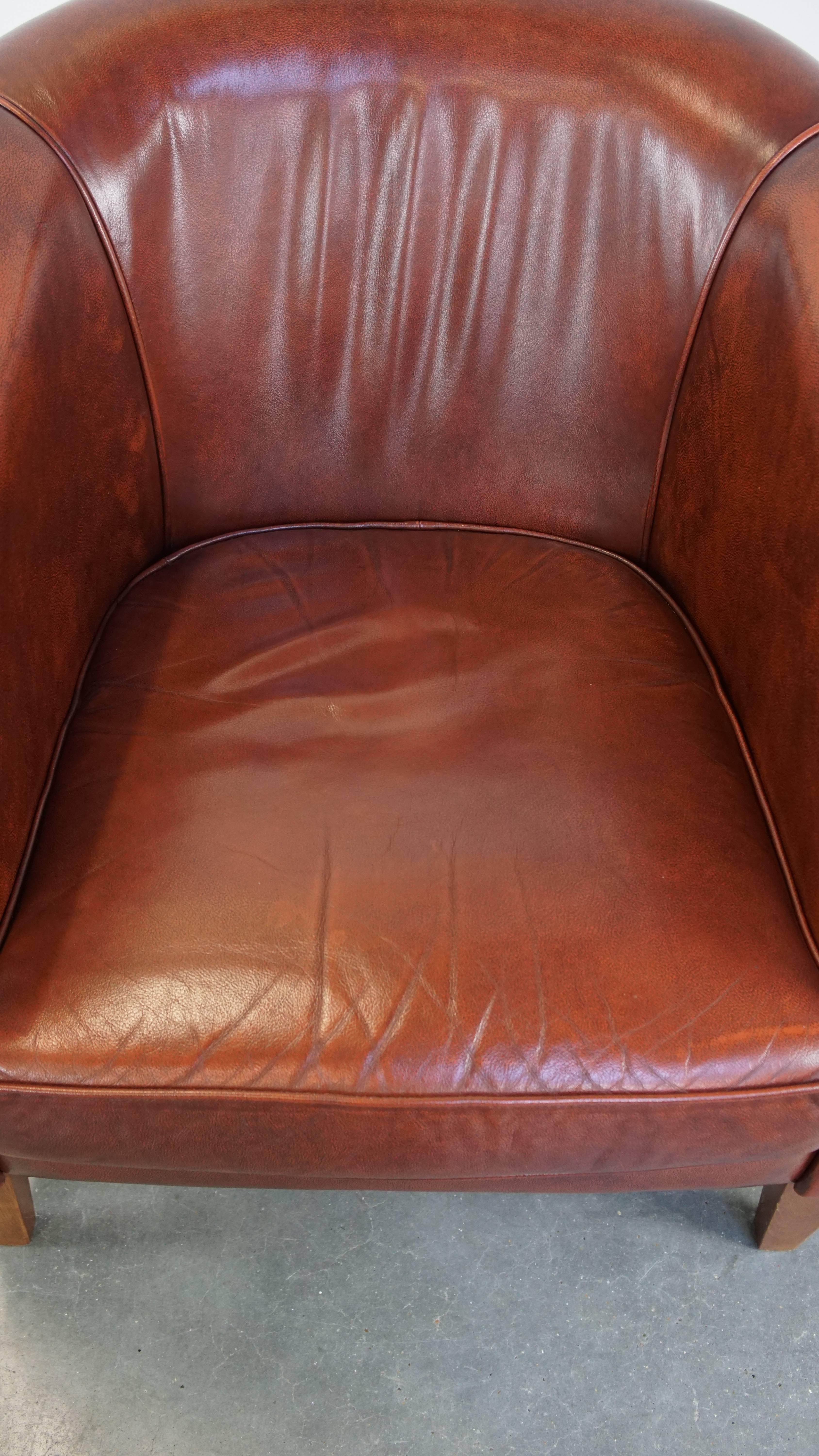Cowhide Sleek, luxurious cow leather oxblood red club chair in good condition For Sale