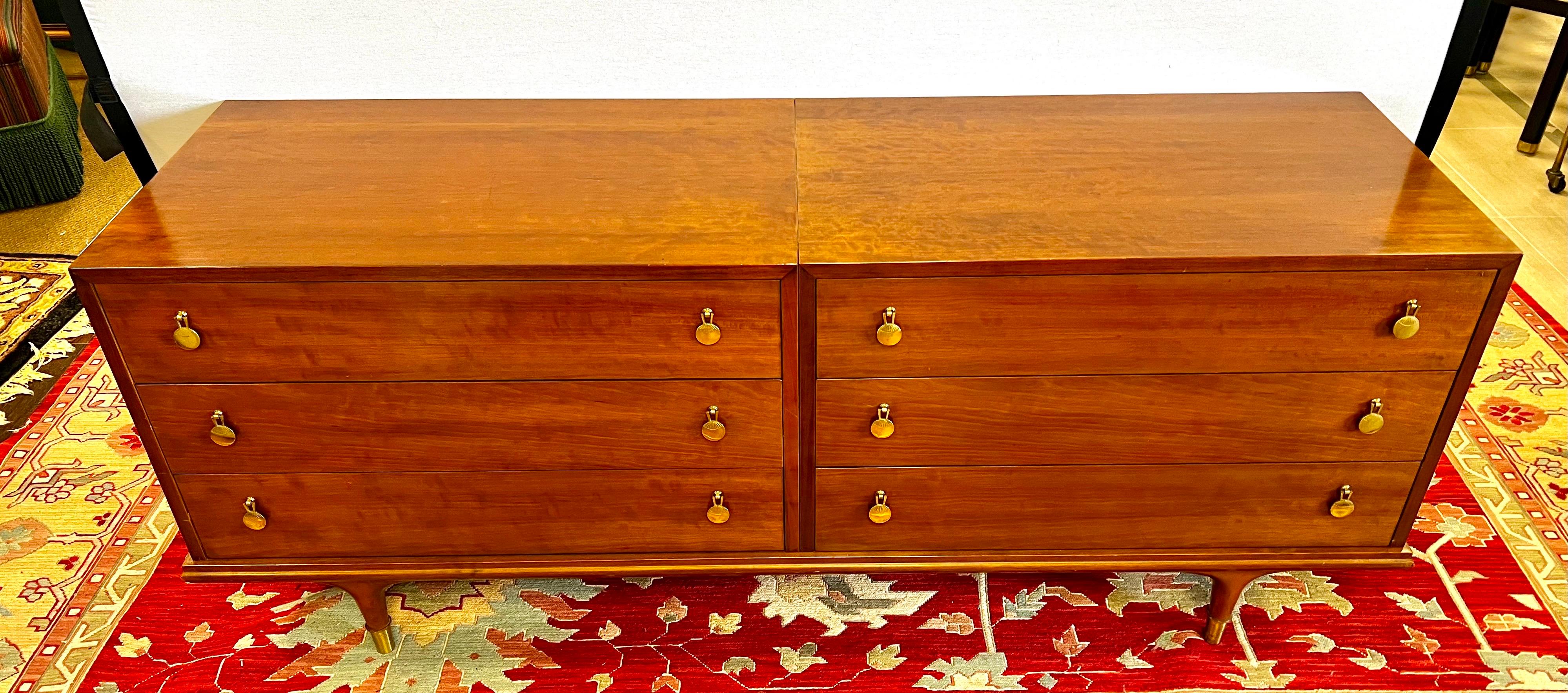 Sleek and elegant mid century walnut dresser with 6 spacious drawers. Features stylized brass pulls and brass capped feet. By John Stuart.