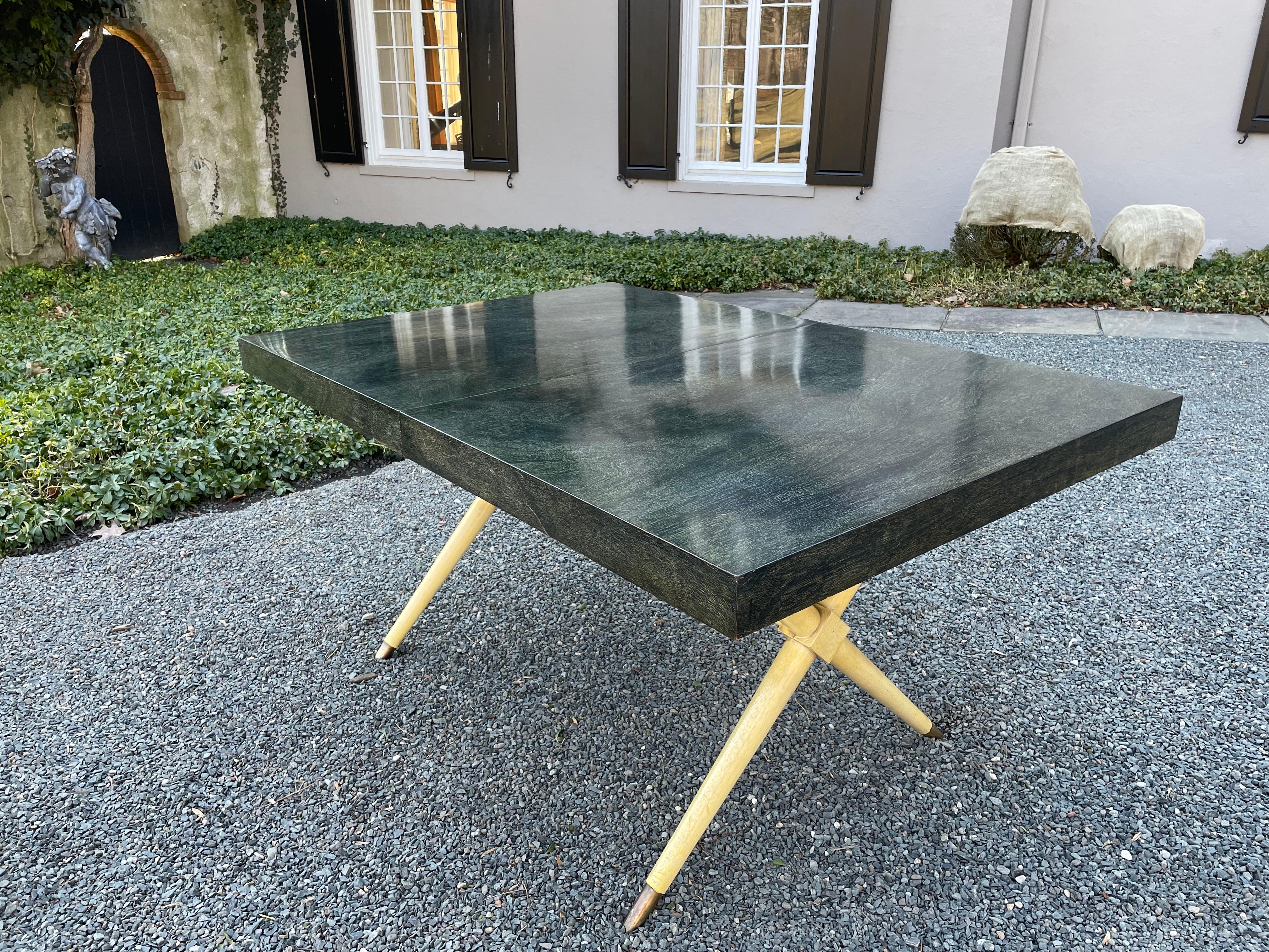 Sophisticated Mid-Century Modern writing table having a mahogany top with a stunning green black finish. The legs have an X design with contrasting light cream finish, black details and brass capped feet. Clean chic lines.