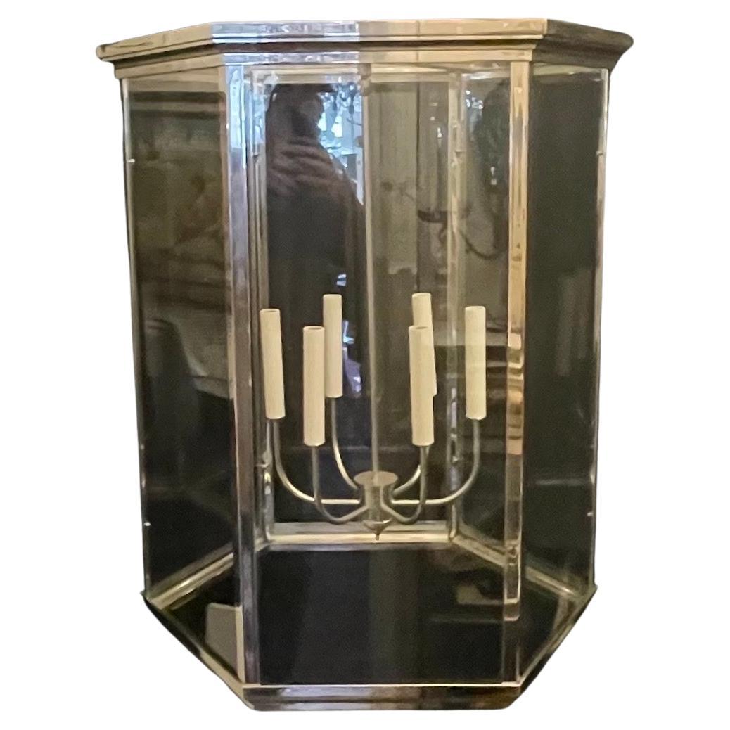 A wonderful sleek modern art deco style large polished nickel octagonal with glass panel lantern fixture having 6 candelabra sockets on the interior, accompanied by chain, canopy and mounting hardware for installation.