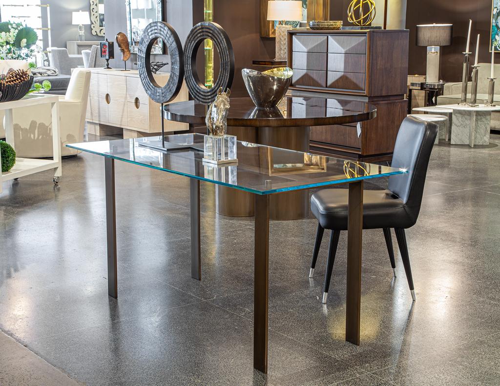 Eleva tu espacio de trabajo con este sofisticado y moderno escritorio fabricado en Canadá. Presenta una base elegante, forjada a mano y chapada en un rico acabado de latón envejecido. Los acentos circulares de metal aseguran una superficie