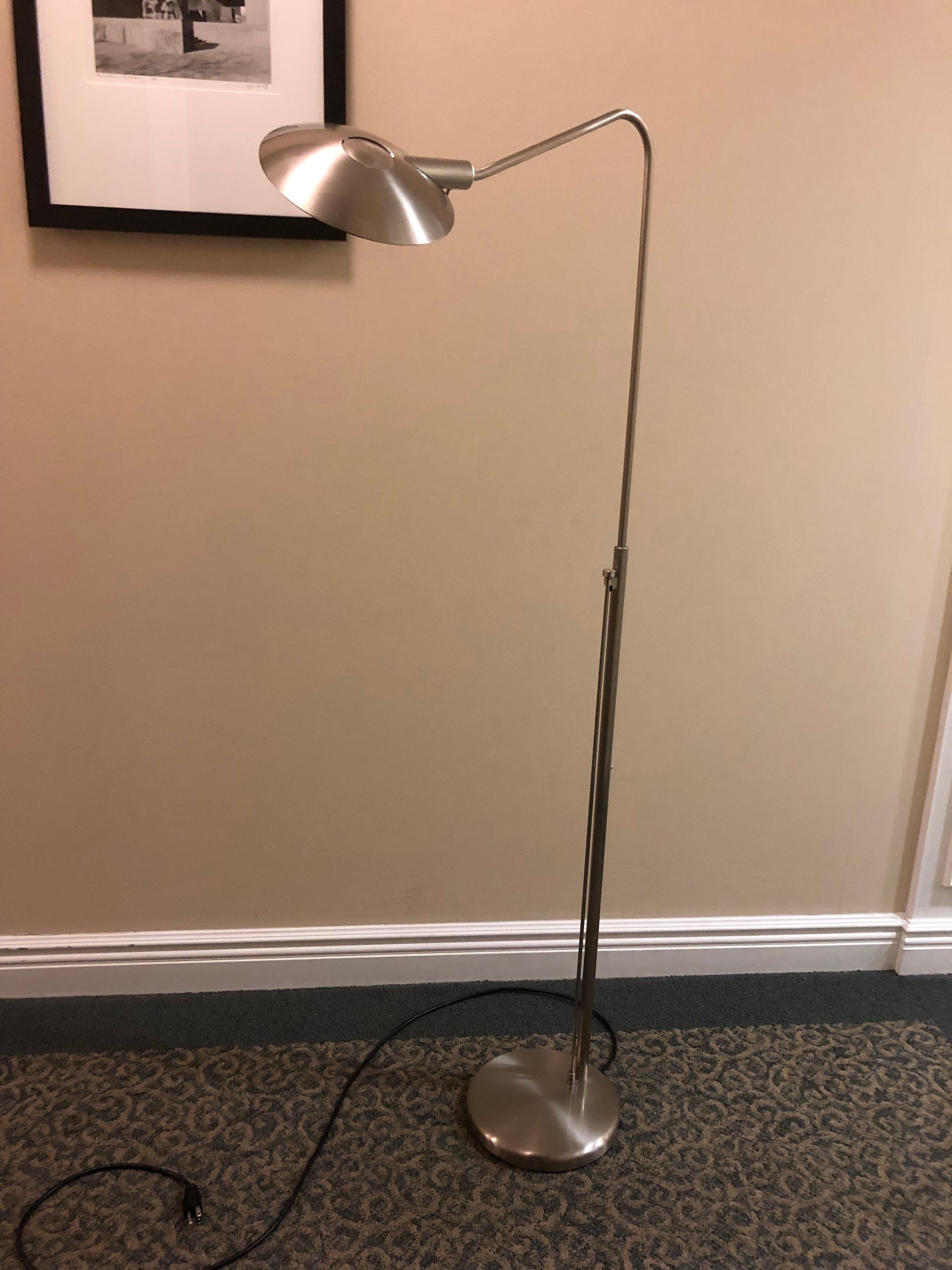 Stylish modern reading floor lamp with swing arm offering both direct and indirect light. Uses 120V/200W halogen bulb. Finished in satin nickel. Shade can be tilted and angled. 
Adjustable height is between 44”and 54” from floor to top of shade.