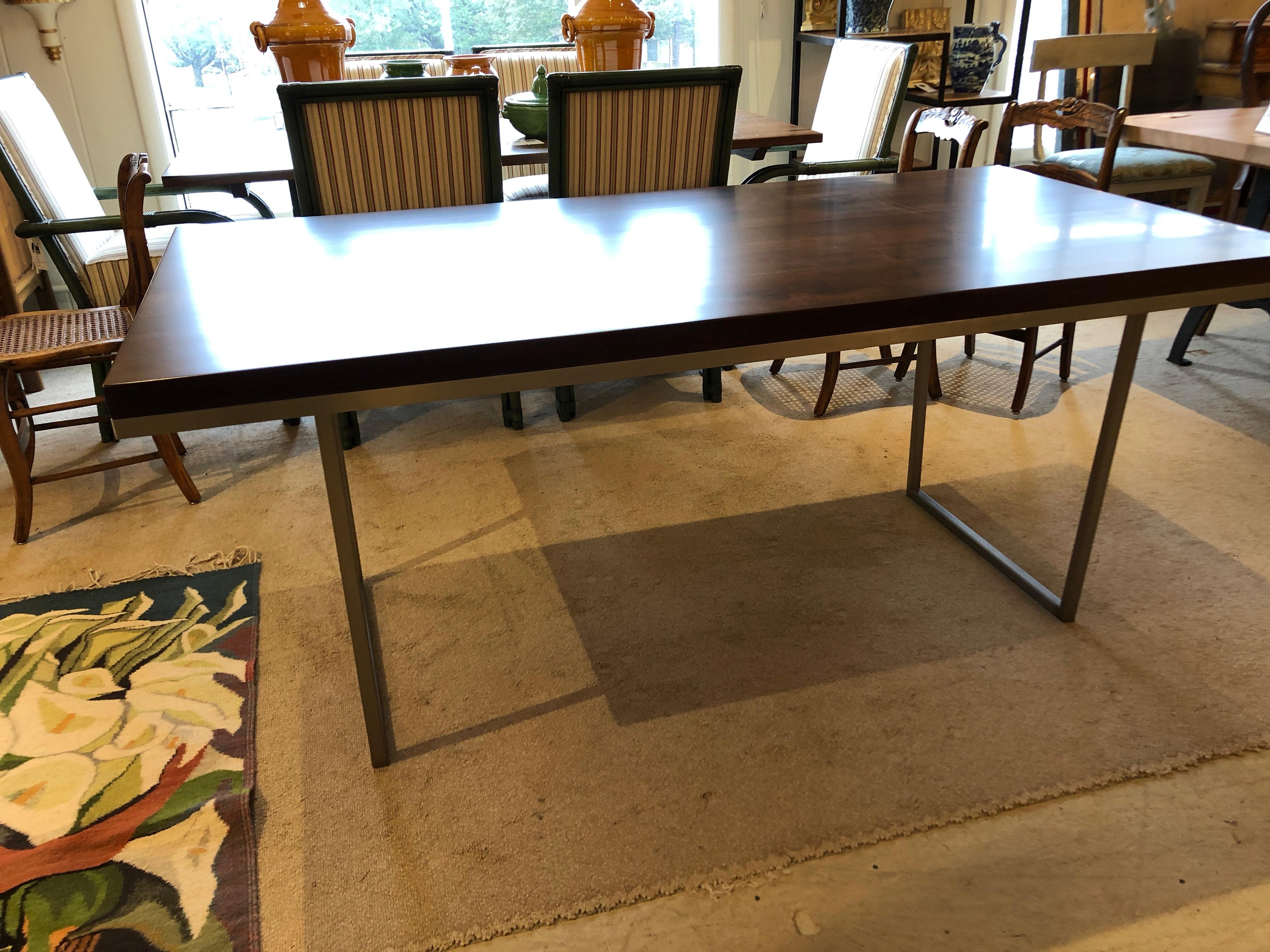 Beautifully handcrafted modern dining table having a sleek walnut top and stainless steel base.  .