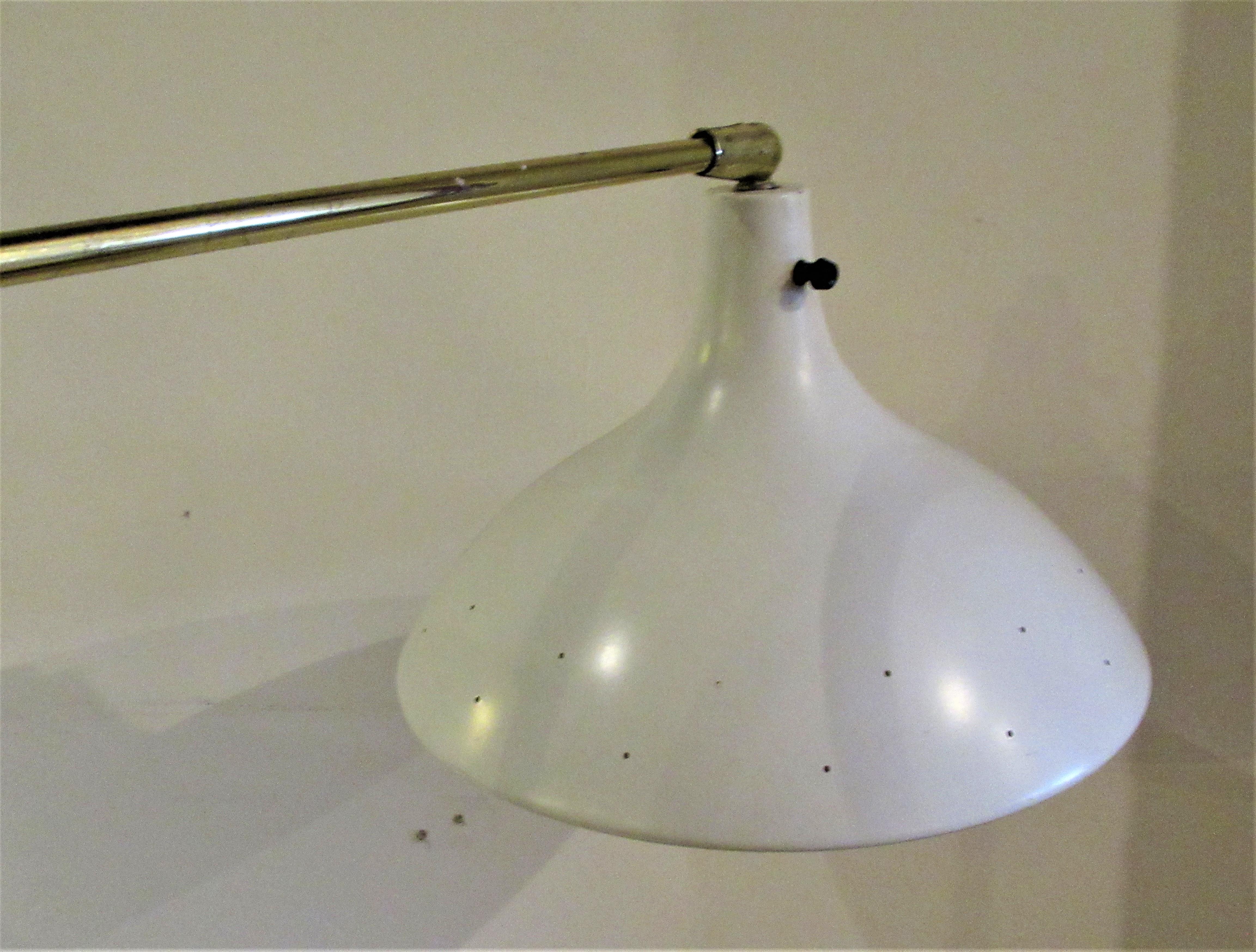 Very sleek modernist bright golden brass floor lamp with pivoting arm and adjustable position original white enamel painted perforated design shade. Attributed to Lightolier, circa 1950-1960. Beautiful lamp - great for reading. See all pictures and