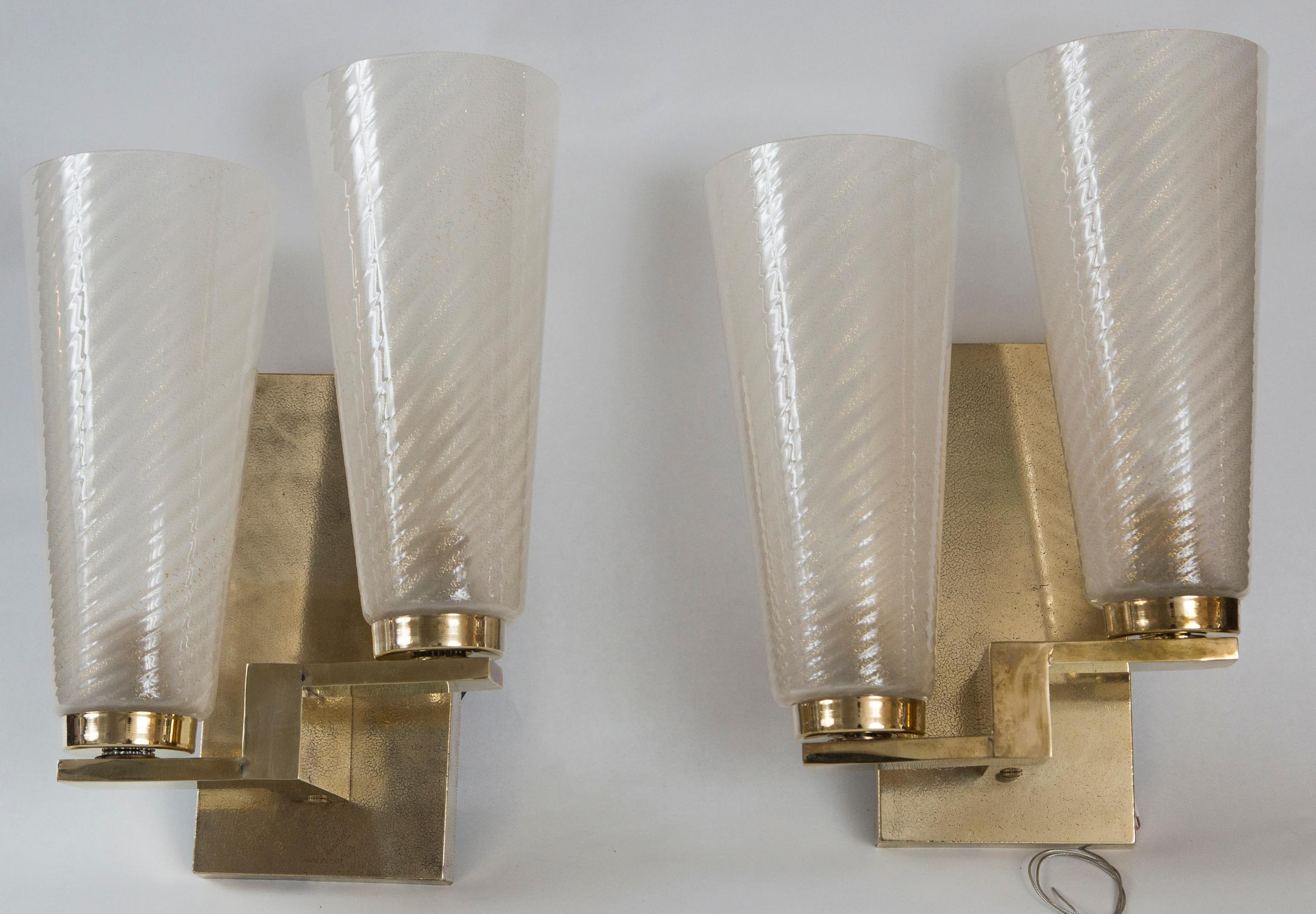 Elegant and modern pair of double gold blown wall lights, beautiful elongated twisting glass cups held by brass fittings, electrified ready with new backplates in solid brass
 
Dimensions
Width 10 in; height 13 in; diameter. 4.5 in.
 

    