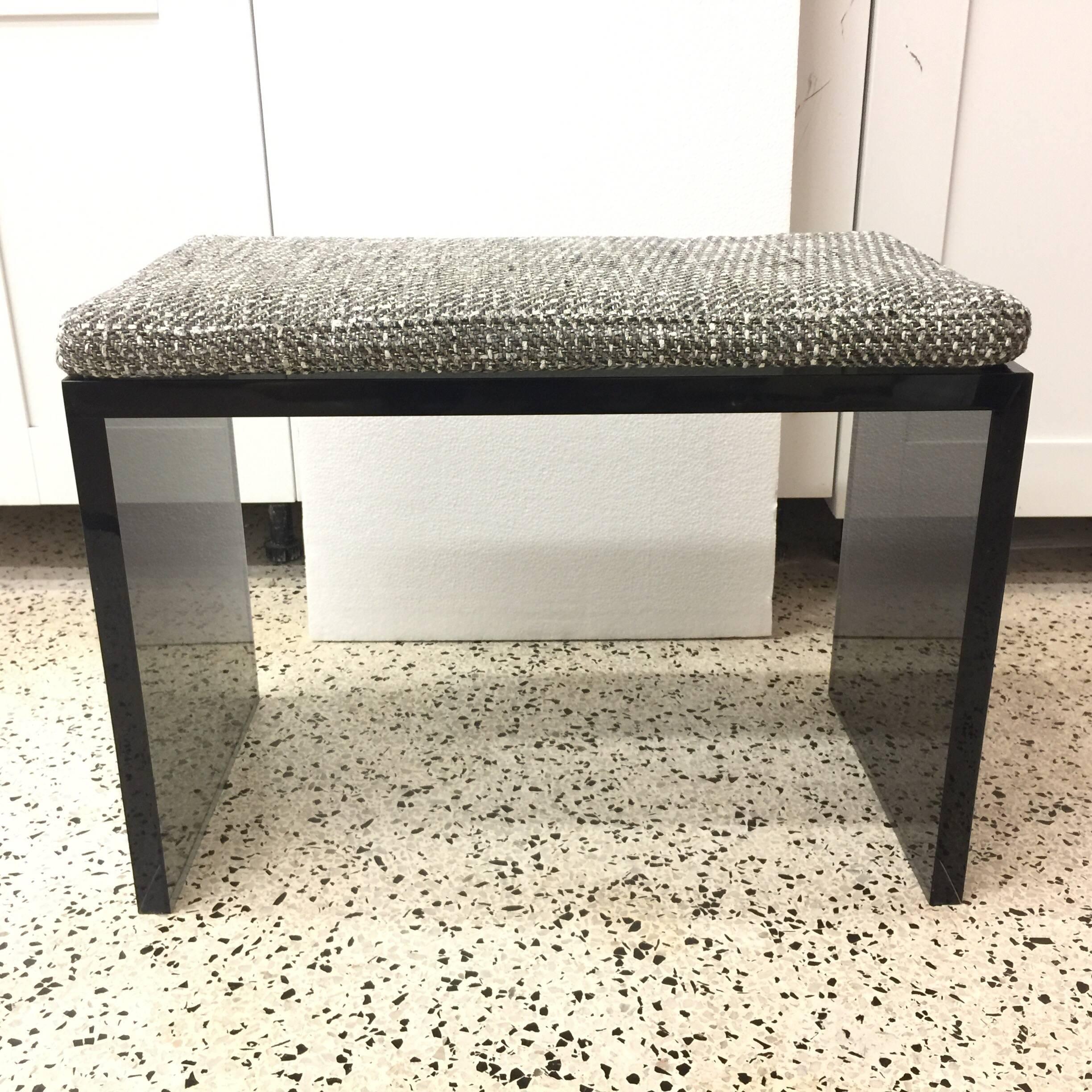 Topped with a Chanel style woven wool fabric and attached with Velcro, these Judd style custom designed smoked grey Lucite benches are perfect for use together or separately. Priced and sold individually.