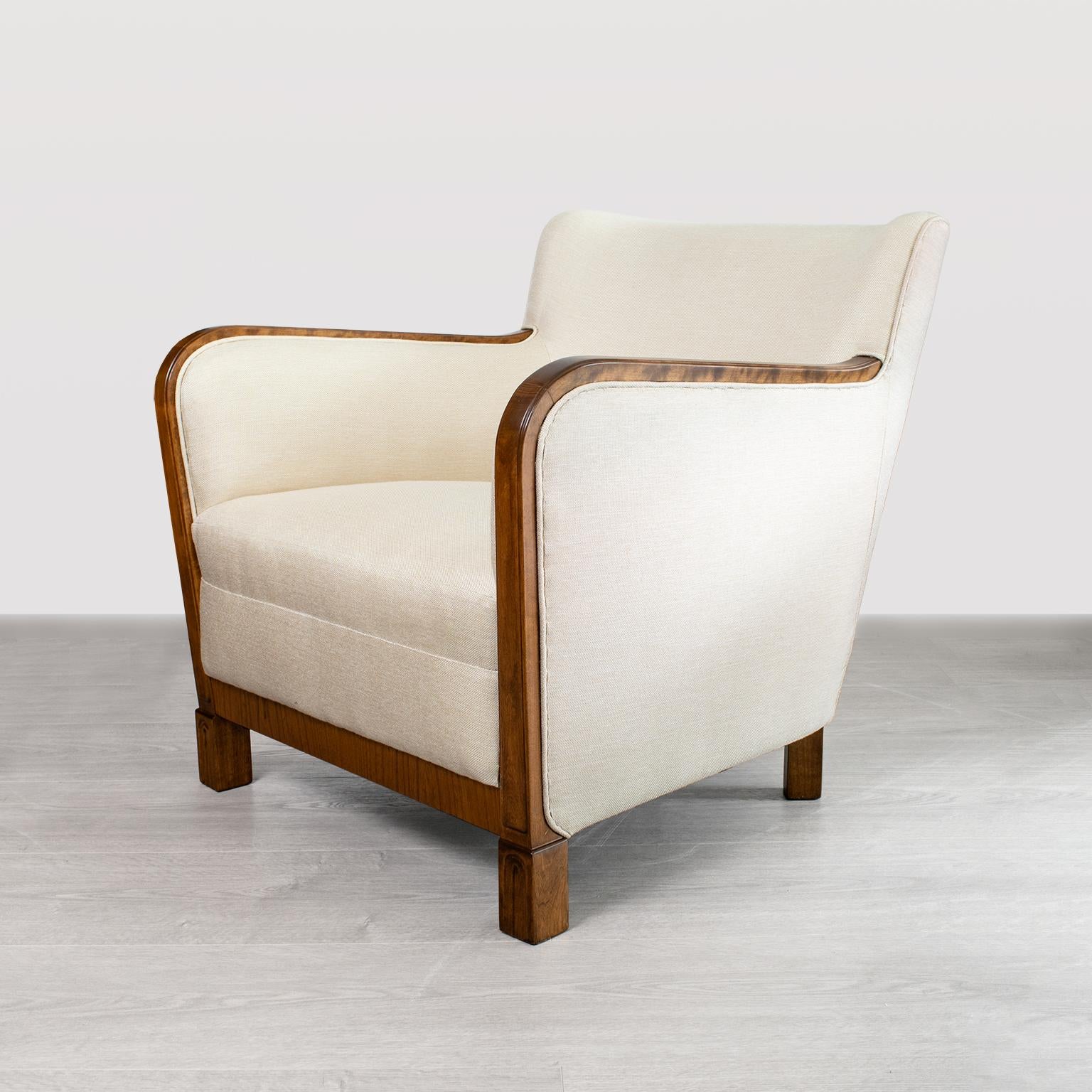 Pair of sleek Scandinavian Modern late 1930s lounge chairs with polished and carved sycamore frames. Newly restored, newly upholstered in textured cream colored fabric.
  