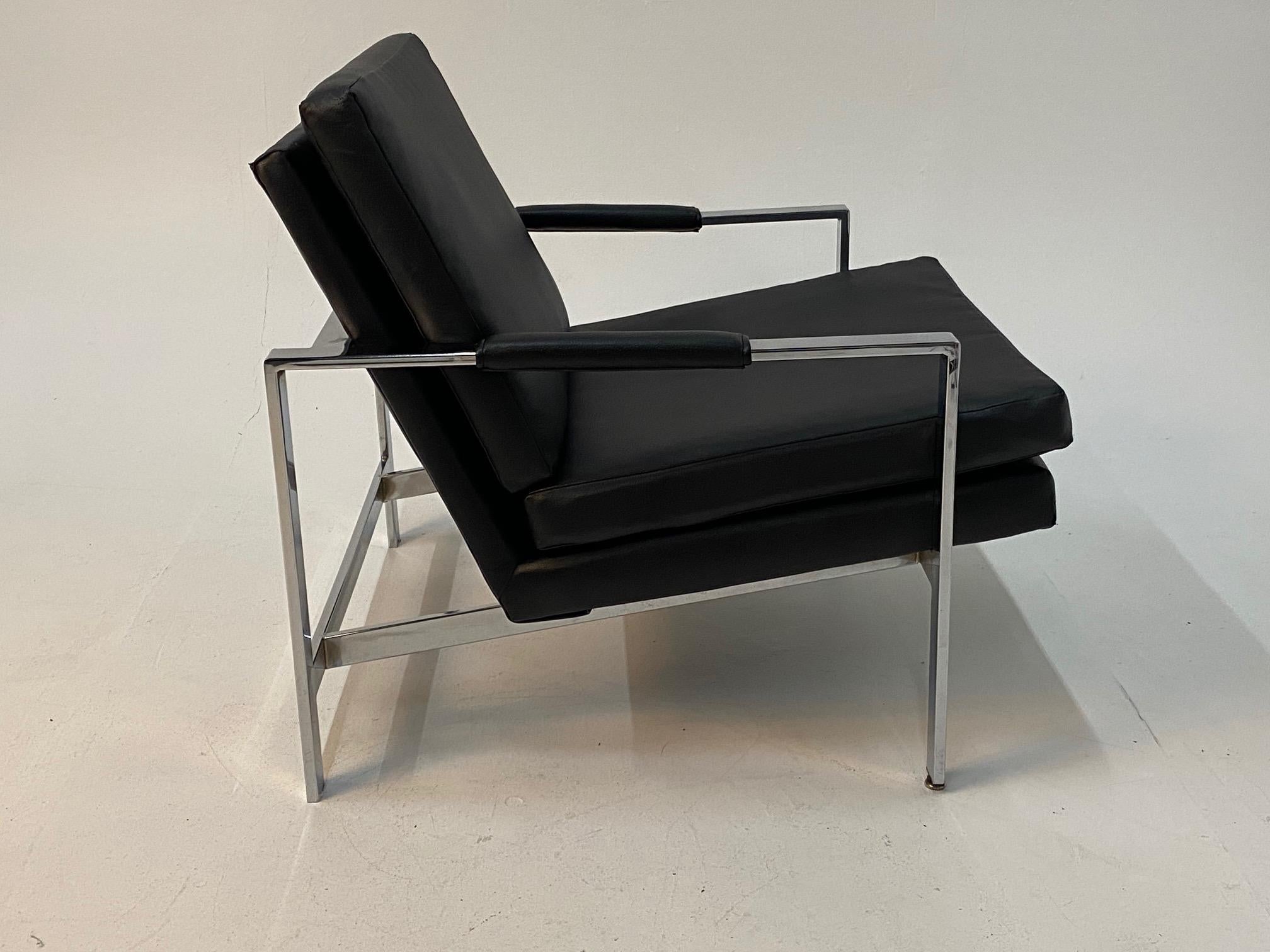 A sophisticated pair of chrome and black vinyl arm chairs  that exude mid century modern class.  No markings, but sure look like Milo Baughman.   Vinyl showing some cracking.
Measure: arm height 19.
